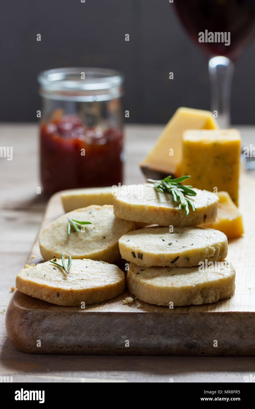 Rosemary crackers with cheddar on cheese board with sweet tomato relish