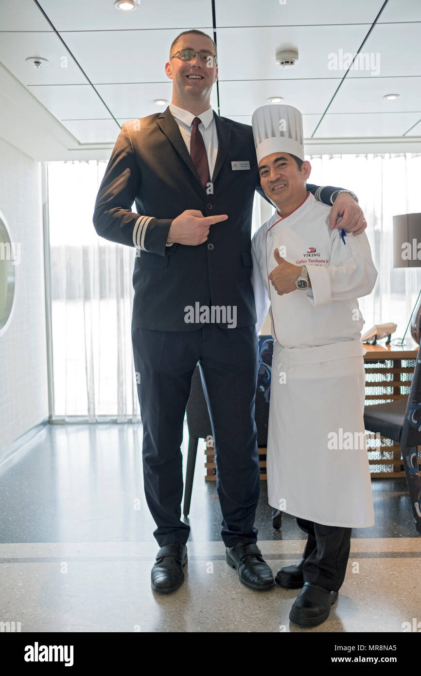 On a Viking Cruise ship the 6 foot 7 Hotel Manager poses with the 5 foot 2 Head chef. On a Danube River cruise. Stock Photo