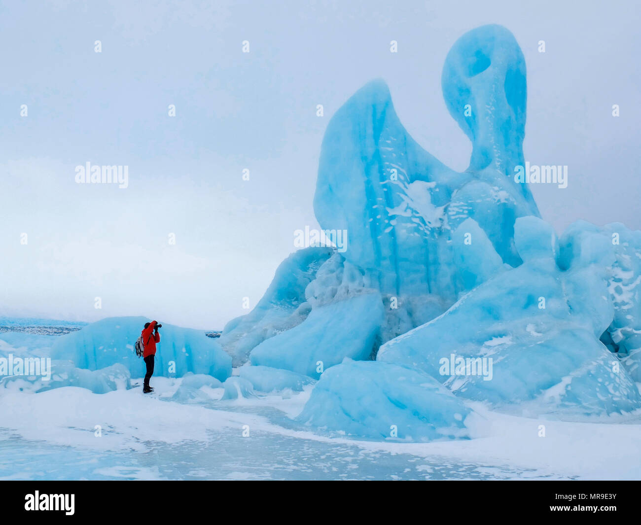 Photographer taking a picture of an iceberg, Knik Glacier, Alaska Stock Photo