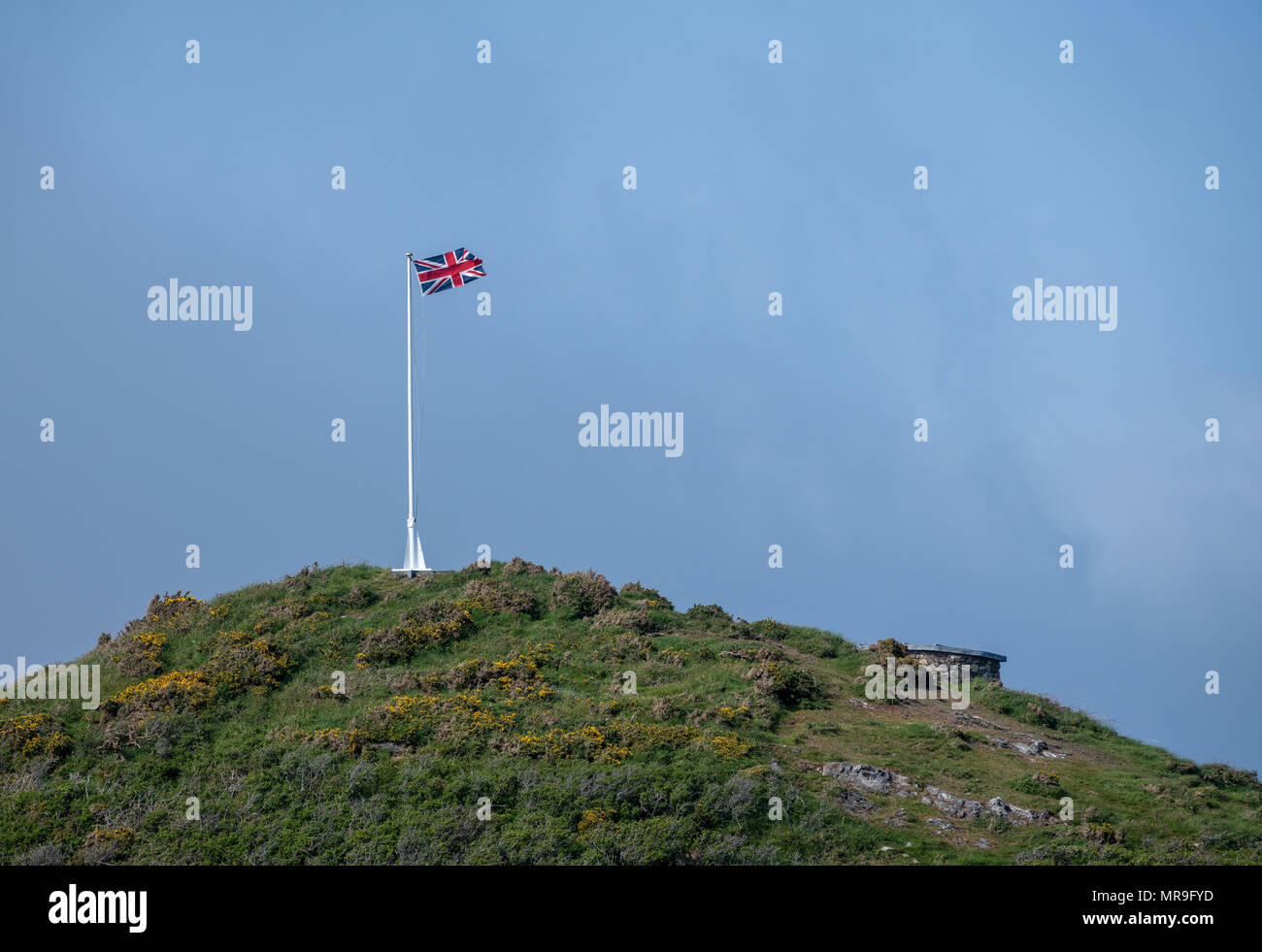 Union flag and flagpole on headland against blue sky Stock Photo - Alamy