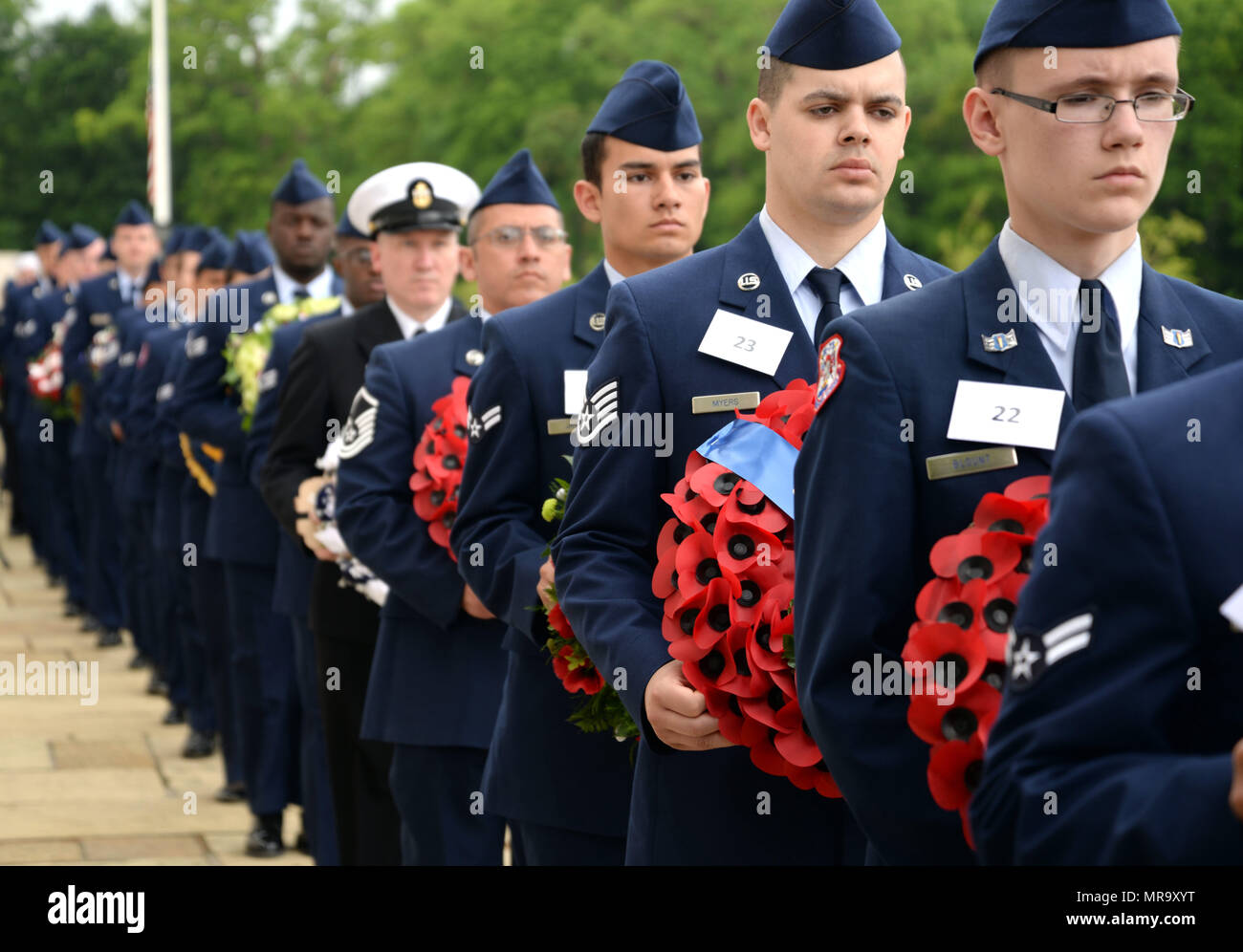 Dozens of Airmen and other U.S. Military Service members carry wreaths donated from several organizations to lay during the Madingley Memorial Day Ceremony May 29, 2017, at Madingley Memorial Cemetery in Cambridge, England. This year volunteers’ collected more than 4,000 portraits of veterans to lay at corresponding headstones within the cemetery. (U.S. Air Force photo by Senior Airman Christine Groening) Stock Photo