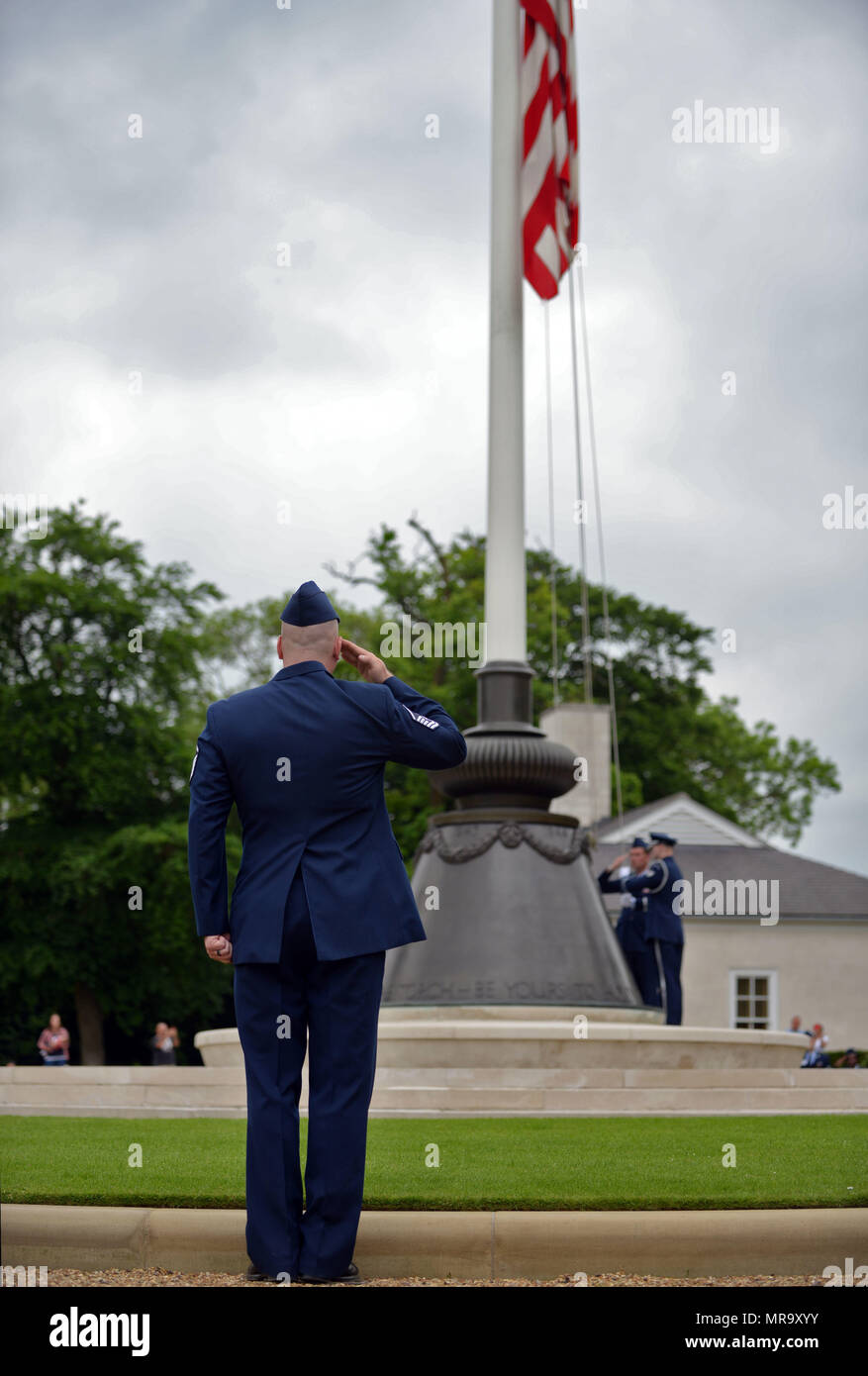 A U.S. Air Force Master Sgt. salutes the U.S. flag during the Madingley Memorial Day ceremony May 29, 2017, at Madingley Memorial Cemetery in Cambridge, England. The Memorial Day ceremony included keynote speakers, wreath laying and fly-overs. (U.S. Air Force photo by Senior Airman Christine Groening) Stock Photo