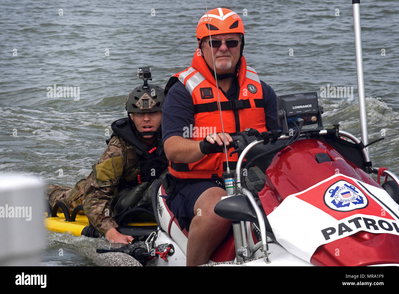 Master Sgt. James Henderson, 181st Weather Flight special operations weatherman, rides with a U.S. Coast Guard Auxiliary member to drop off his parachute gear after a deliberate water drop into Lake Worth in Fort Worth, Texas, May 20, 2017. The mission allowed 12 service members to parachute out of a C-130 Hercules from an altitude of 1000 feet into Lake Worth using MC-6 parachutes. (Texas Air National Guard photo by Staff Sgt. Kristina Overton) Stock Photo