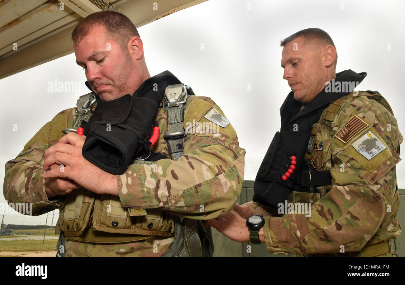 Staff Sgt. Curtis Humphreys, with the assistance of Master Sgt. James Henderson, 181st Weather Flight special operations weathermen, adjusts his parachute gear prior to a deliberate water drop into Lake Worth in Forth Worth, Texas,  May 20, 2017. The jump was part of an exercise to train on tactical skills when operating in hostile and denied territories.(Texas Air National Guard photo by Staff Sgt. Kristina Overton) Stock Photo