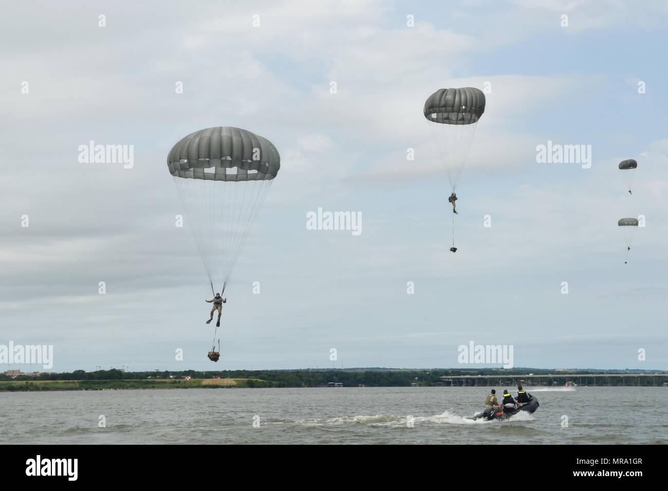 Members of the 181st Weather Flight parachute into Lake Worth after jumping out of a C-130 Hercules during a deliberate water drop in Forth Worth, Texas, May 20, 2017. The training mission was scheduled for members to practice airborne covert water parachute infiltration and included a joint effort between the Texas Air National Guard, Army, Coast Guard Auxiliary, and local fire department. (Texas Air National Guard photo by Staff Sgt. Kristina Overton) Stock Photo