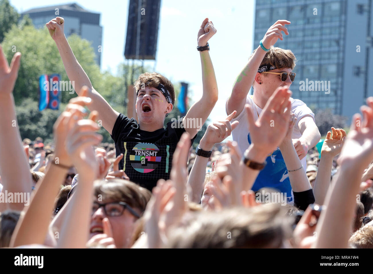 Excited music fans in the crowd at the first TRNSMT Festival. One is wearing a branded t-shirt. Glasgow Green, Glasgow, UK. Stock Photo