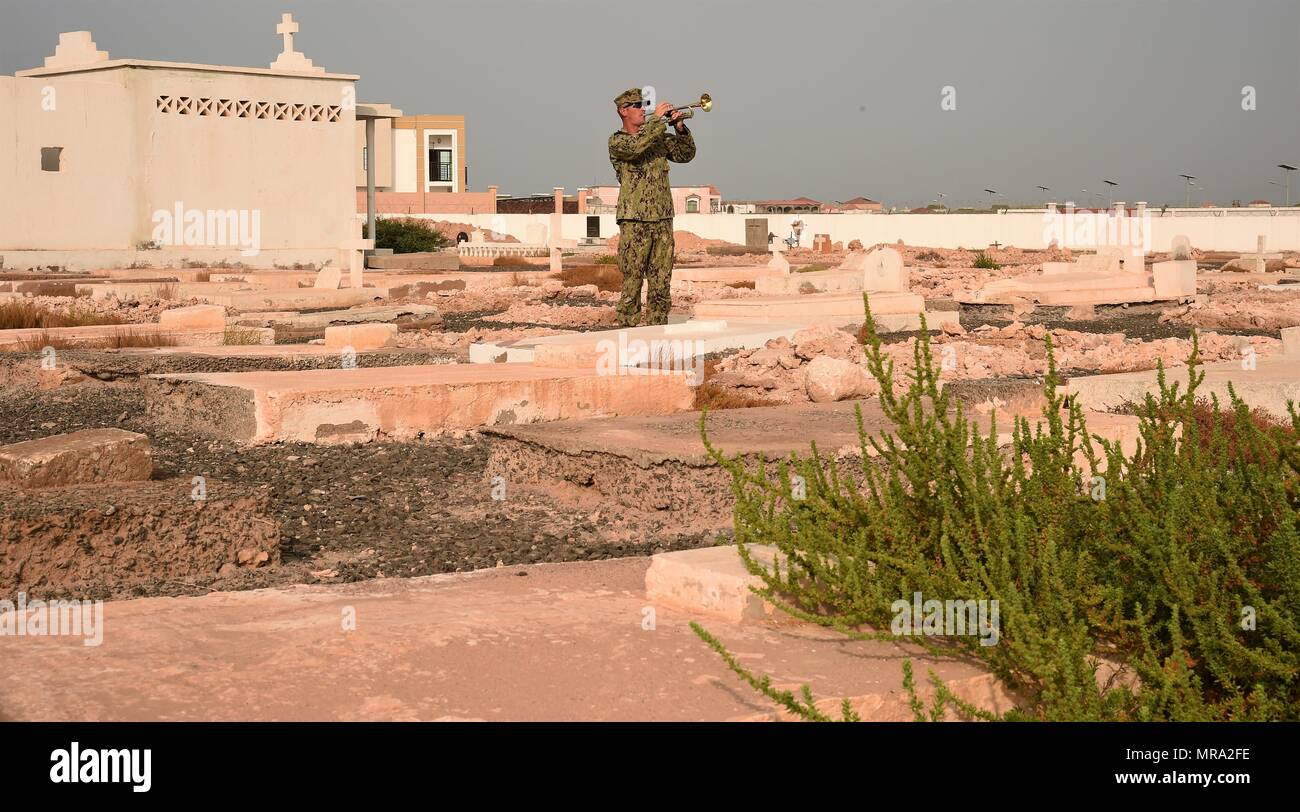 U.S. Navy Petty Officer 1st Class James Geiger, a Combined Joint Task Force – Horn of Africa Seabee, plays taps during the Memorial Day commemoration ceremony for Pilot Officer Lawrence Maguire at the Djibouti New European Cemetery, Djibouti, May 29, 2017. Maguire applied to the U.S. Naval Academy, the FBI and the British American Ambulance Corps prior to joining the Royal Canadian Air Force in 1940. (U.S. Air National Guard photo by Tech. Sgt. Andria Allmond) Stock Photo