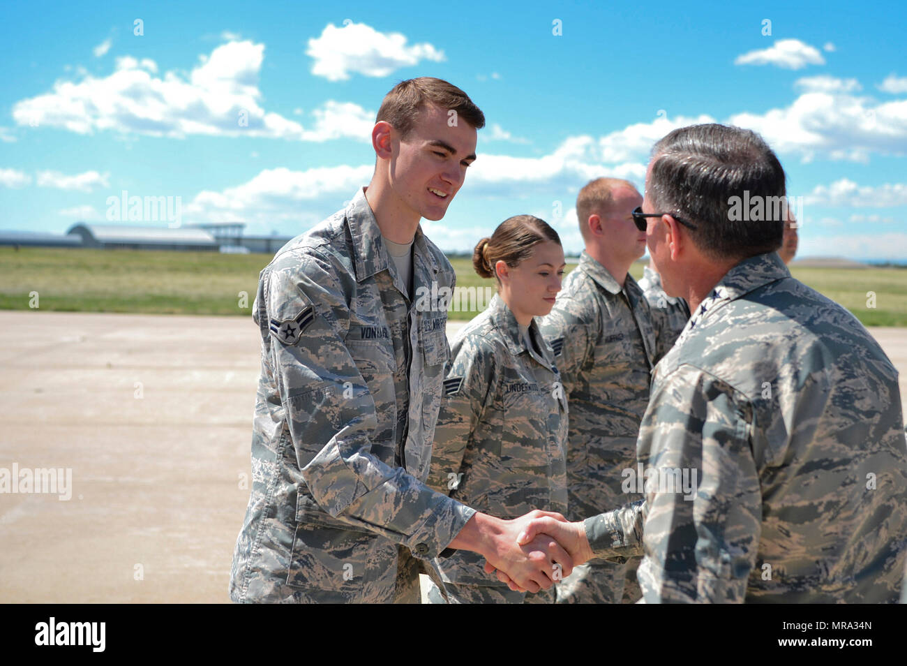 Gen. David L. Goldfein, Chief of Staff of the U.S. Air Force, gives Airman 1st Class Christopher Von Haasl, 140th Maintenance Squadron F-16 Fighting Falcon hydraulics technician, a coin in recognition of his hard work during his visit May 25, 2017, on Buckley Air Force Base, Colo. During his visit, Goldfein walked through several static displays for a mission brief from the 140th Wing, met with space operators from the 460th Operations Group and toured the Aerospace Data-Facility-Colorado. (U.S. Air Force photo by Airman 1st Class Holden S. Faul/ Released) Stock Photo
