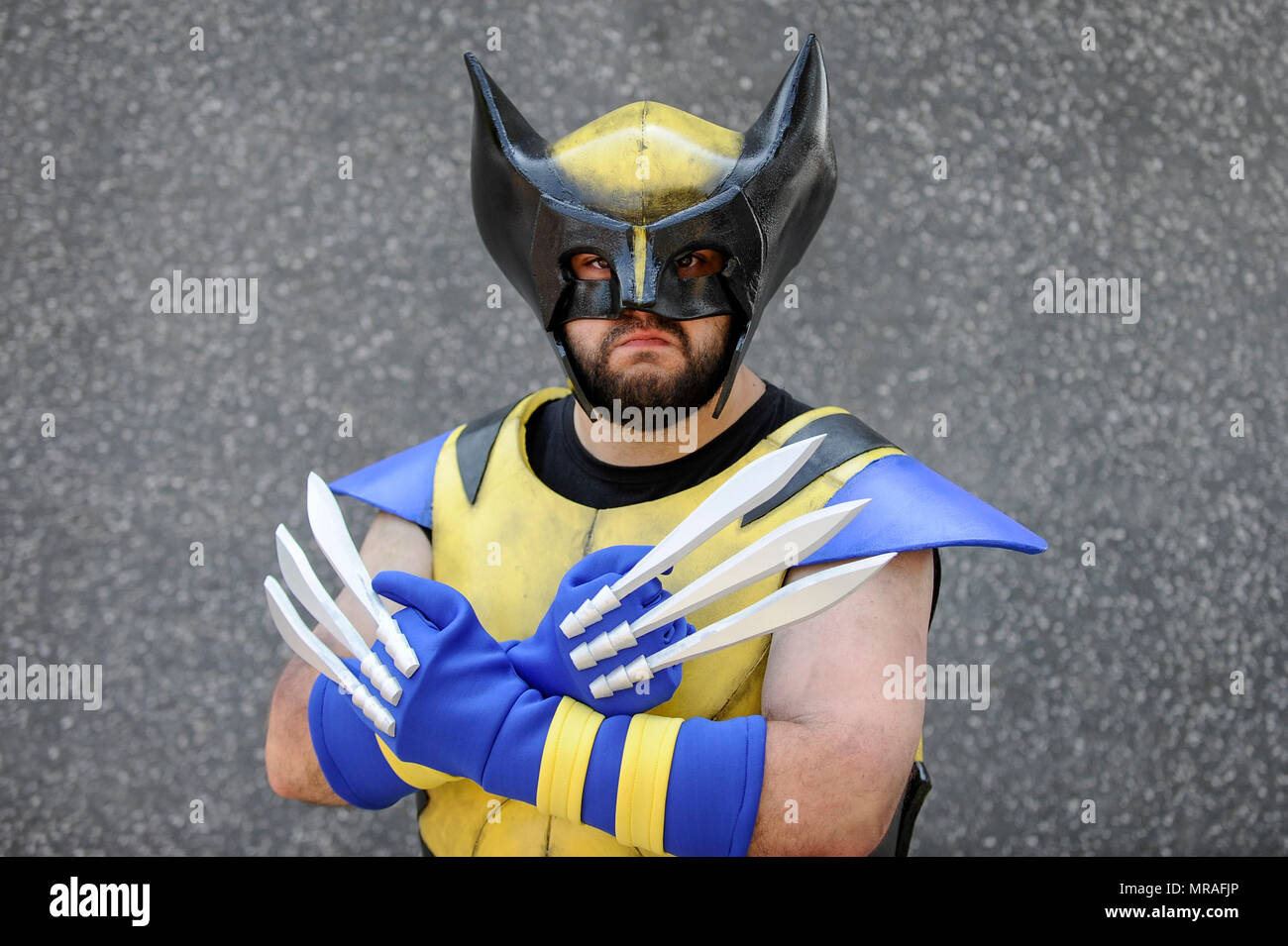 London, UK. 26 May 2018. A man dressed as Wolverine from X-Men joins  cosplayers attending day two of MCM Comic Con at Excel in East London.  Thousands of fans of video games,