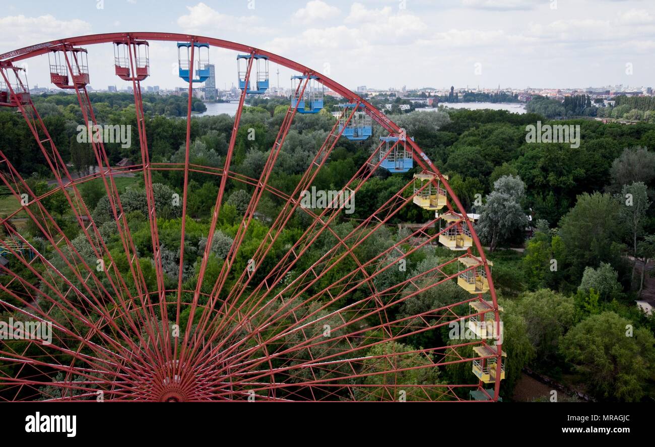 25 May 2018, Germany, Berlin: A ferris wheel standing in the former GDR amusement 'Spreepark' looms over the Plaenterwald area. The abandoned park is to be revamped and re-opened. Photo: Kay Nietfeld/dpa Stock Photo