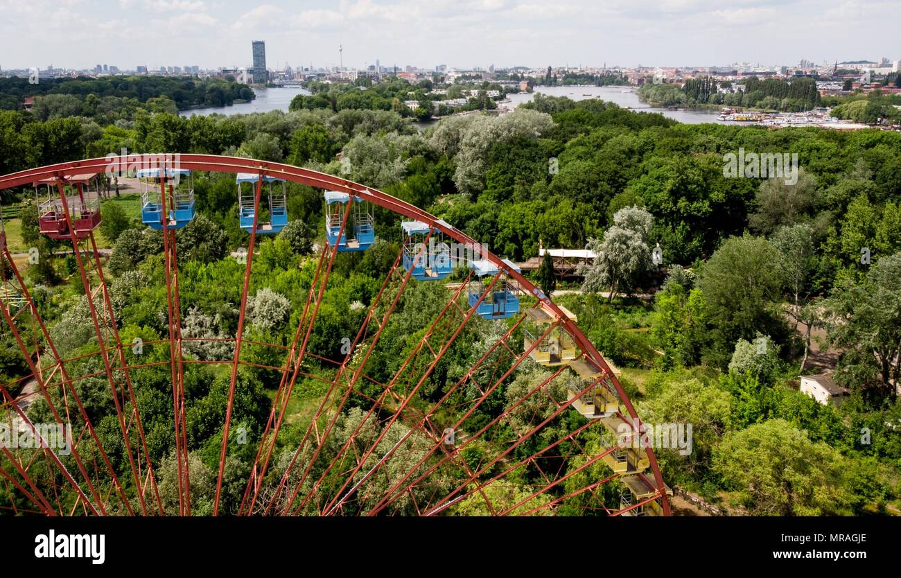 25 May 2018, Germany, Berlin: A ferris wheel standing in the former GDR amusement 'Spreepark' looms over the Plaenterwald area. The abandoned park is to be revamped and re-opened. Photo: Kay Nietfeld/dpa Stock Photo