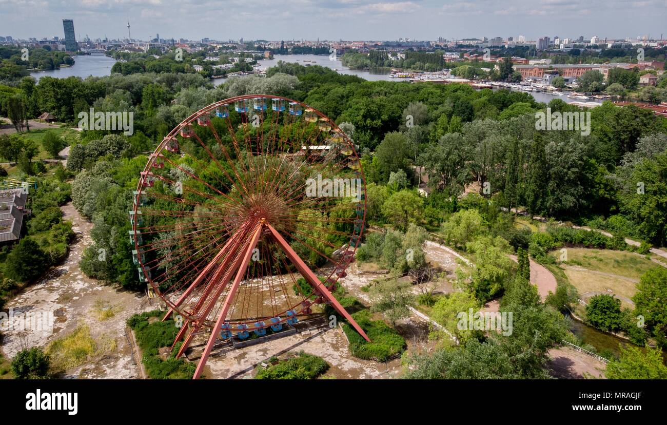 25 May 2018, Germany, Berlin: A ferris wheel standing in the former GDR amusement 'Spreepark' looms over the Plaenterwald area. The abandoned park is to be revamped and re-opened. Photo: Kay Nietfeld/dpa Stock Photo