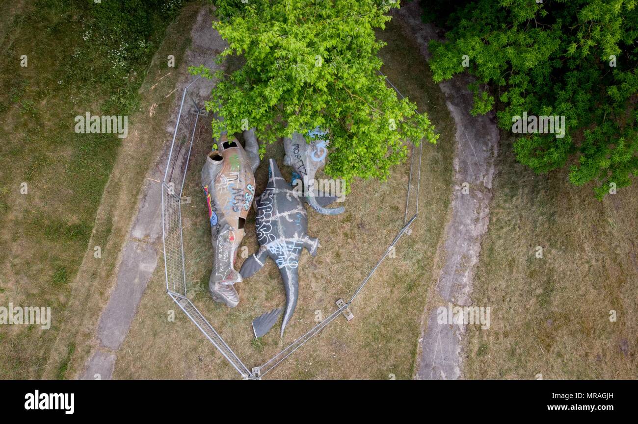 25 May 2018, Germany, Berlin: Destroyed dinosaur figures lie on the premises of the former GDR amusement 'Spreepark' at the Plaenterwald. The abandoned park is to be revamped and re-opened. Photo: Kay Nietfeld/dpa Stock Photo