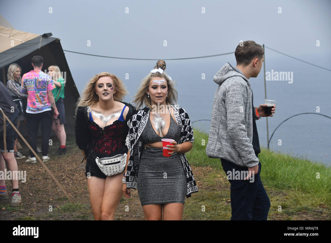 Porthleven, Cornwall, UK. 26th May 2018. UK Weather. Despite spells of heavy rain, these revellers continued to enjoy themselves at the Masked Ball party at Cornwall. Credit: Simon Maycock/Alamy Live News Stock Photo