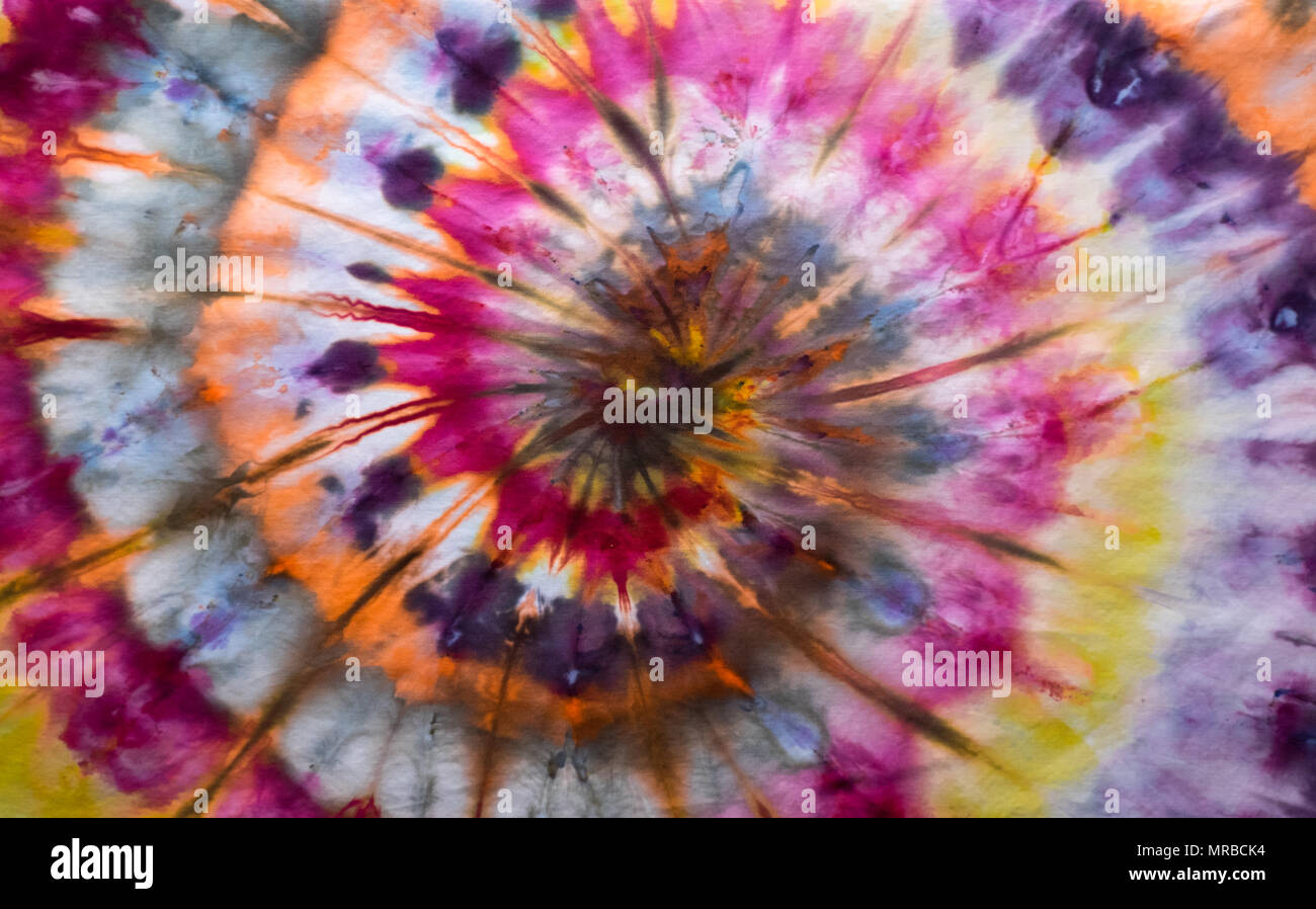 Tye Dye Swirl Pattern featuring Orange, Purple, Yellow, Pink, White and Blue Hues. Stock Photo