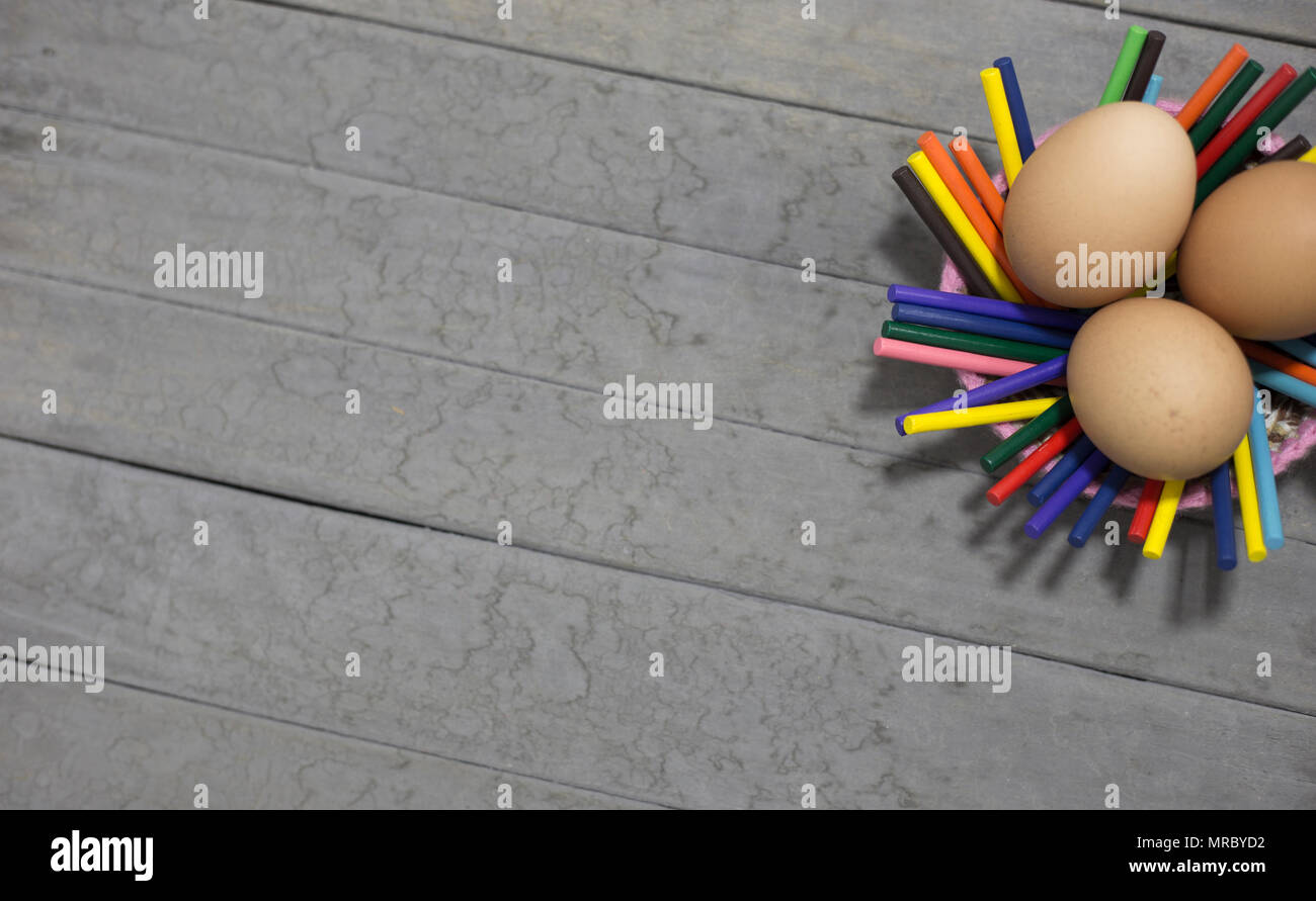 three eggs and sticks on gray background Stock Photo