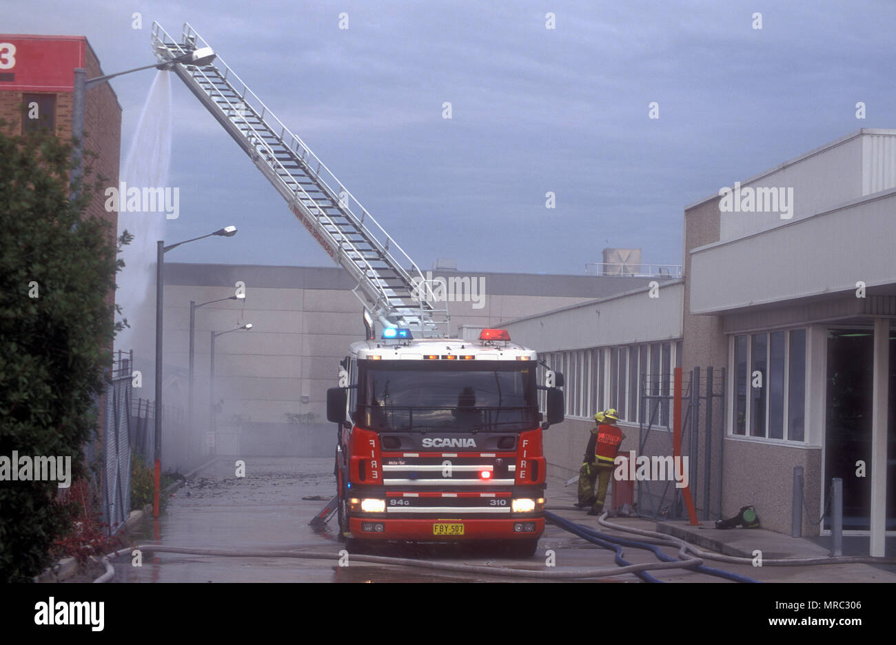 FIREMEN PUT OUT A FACTORY FIRE, SYDNEY, NEW SOUTH WALES, AUSTRALIA Stock Photo