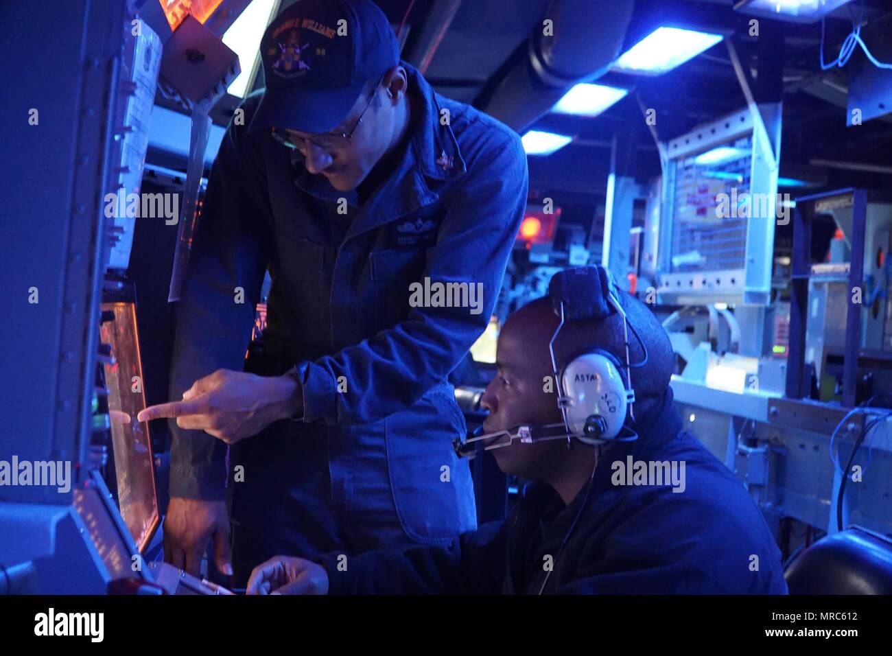 170601-N-QX001-001  ATLANTIC OCEAN (June 1, 2017) Operations Specialist 2nd Class Kenneth Davis, from Johnston, South Carolina, discusses helicopter operations with Operations Specialist 1st Class Steven Gross, from Baltimore, aboard the Arleigh Burke-class guided-missile destroyer USS James E. Williams. James E. Williams, homeported in Norfolk, is on a routine deployment to the U.S. 6th Fleet area of operations in support of U.S. national security interests in Europe. (U.S. Navy photo by Lt. j.g. Reuben Carson/Released) Stock Photo