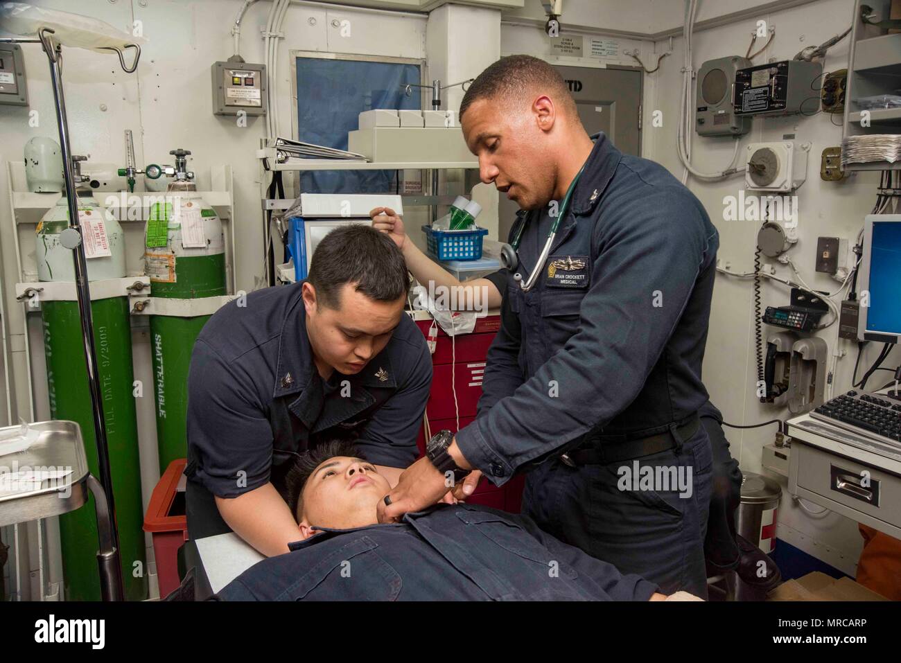170603-N-KJ380-240  ATLANTIC OCEAN (June 3, 2017) Hospital Corpsman 1st Class Frederick Ehlers, left, and Hospital Corpsman 2nd Class Brian Crockett examine Midshipman 1st Class Justin Bongco during a medical emergency drill aboard the aircraft carrier USS Dwight D. Eisenhower (CVN 69) (Ike). Ike is currently conducting aircraft carrier qualifications during the sustainment phase of the Optimized Fleet Response Plan (OFRP). (U.S. Navy photo by Mass Communication Specialist Seaman Neo B. Greene III) Stock Photo