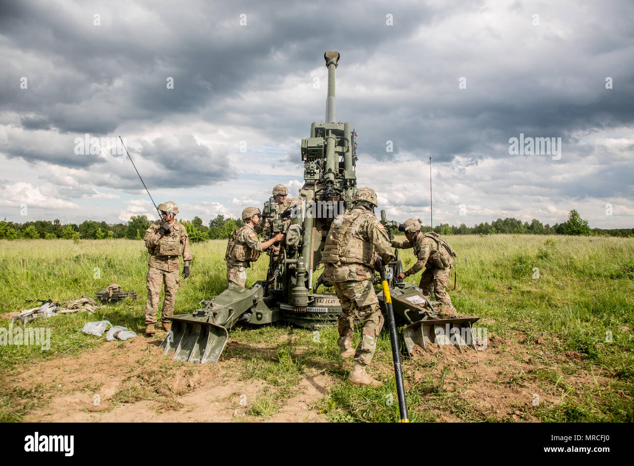 Battle Group Poland U.S. Solders, assigned to Bulldog Battery, 2nd Squadron, 2nd Cavalry Regiment, along with 10th Mountain Combat Aviation Brigade, conduct sling load and air assault training with M777A2 Howitzers, during Saber Strike 2017, at Bemowo Piskie Training Area near Orzysz, Poland, June 7, 2017. Saber Strike17 is a U.S. Army Europe-led multinational combined forces exercise conducted annually to enhance the NATO alliance throughout the Baltic region and Poland. This year's exercise includes integrated and synchronized deterrence- oriented training designed to improve interoperabilit Stock Photo
