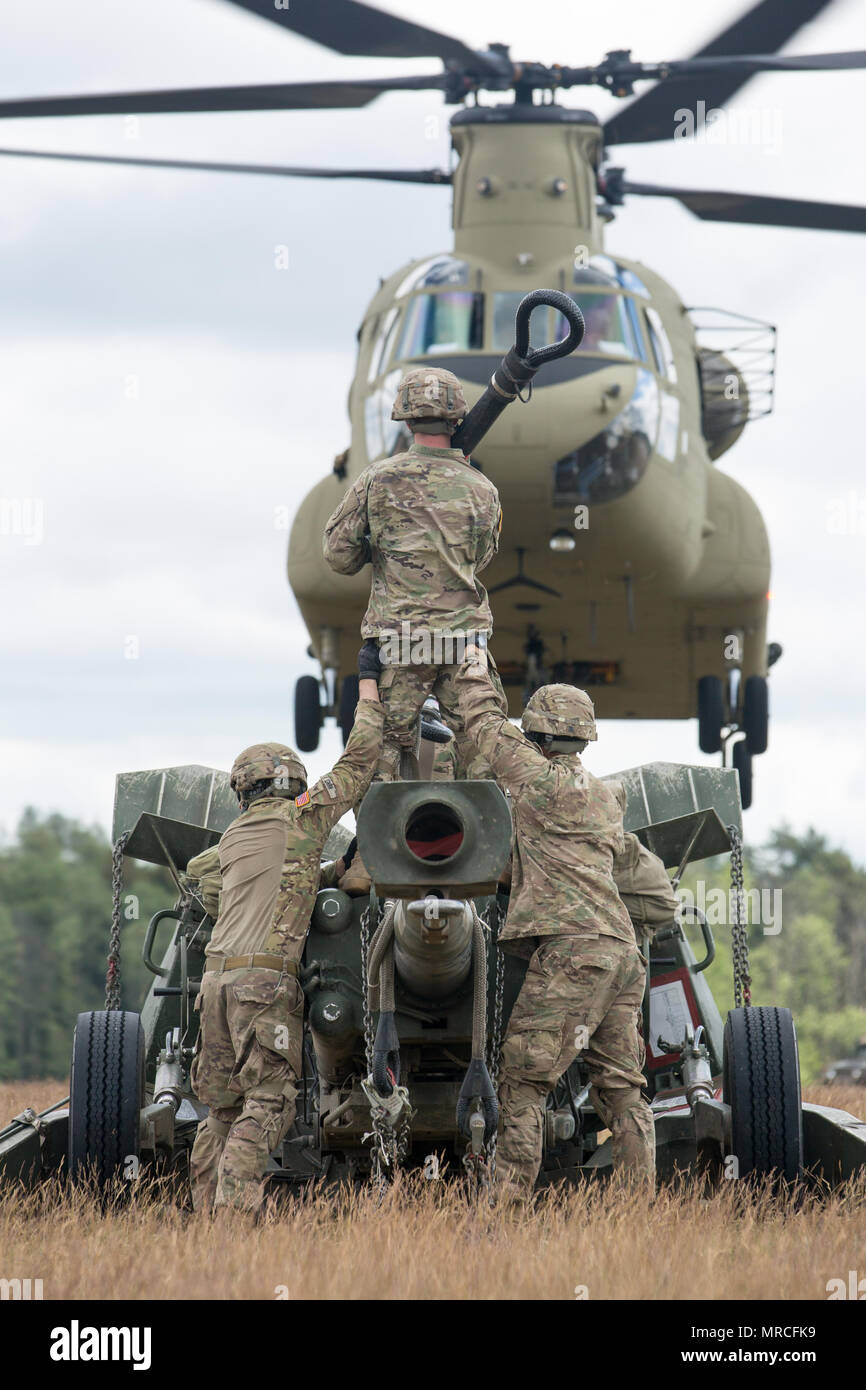 Battle Group Poland U.S. Soldiers, assigned to Bulldog Battery, 2nd Squadron, 2nd Cavalry Regiment, along with 10th Mountain Combat Aviation Brigade, conduct sling load and air assault training with M777A2 Howitzers, during Saber Strike 2017, at Bemowo Piskie Training Area near Orzysz, Poland, June 7, 2017. Saber Strike17 is a U.S. Army Europe-led multinational combined forces exercise conducted annually to enhance the NATO alliance throughout the Baltic region and Poland. This year's exercise includes integrated and synchronized deterrence-oriented training designed to improve interoperabilit Stock Photo