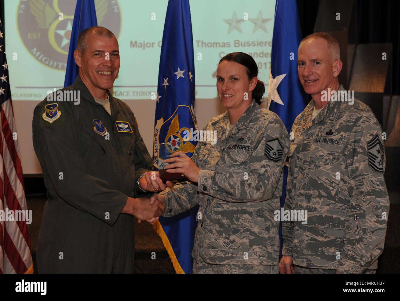 U.S. Air Force Maj. Gen. Thomas Bussiere, Eighth Air Force commander, left, and Chief Master Sgt. Alan Boling, Eighth Air Force command chief, far right, recognizes Airman 1st Class Krystal Cleary, 608th Air Operations Center (not pictured) as a Diamond Sharp Award winner for the month of December during a Headquarters Eighth Air Force commanders call at Barksdale Air Force Base, La., April 12, 2017. Various topics pertinent to the organization were discussed throughout the event, followed by a question and answer engagement session with the Airmen. Stock Photo