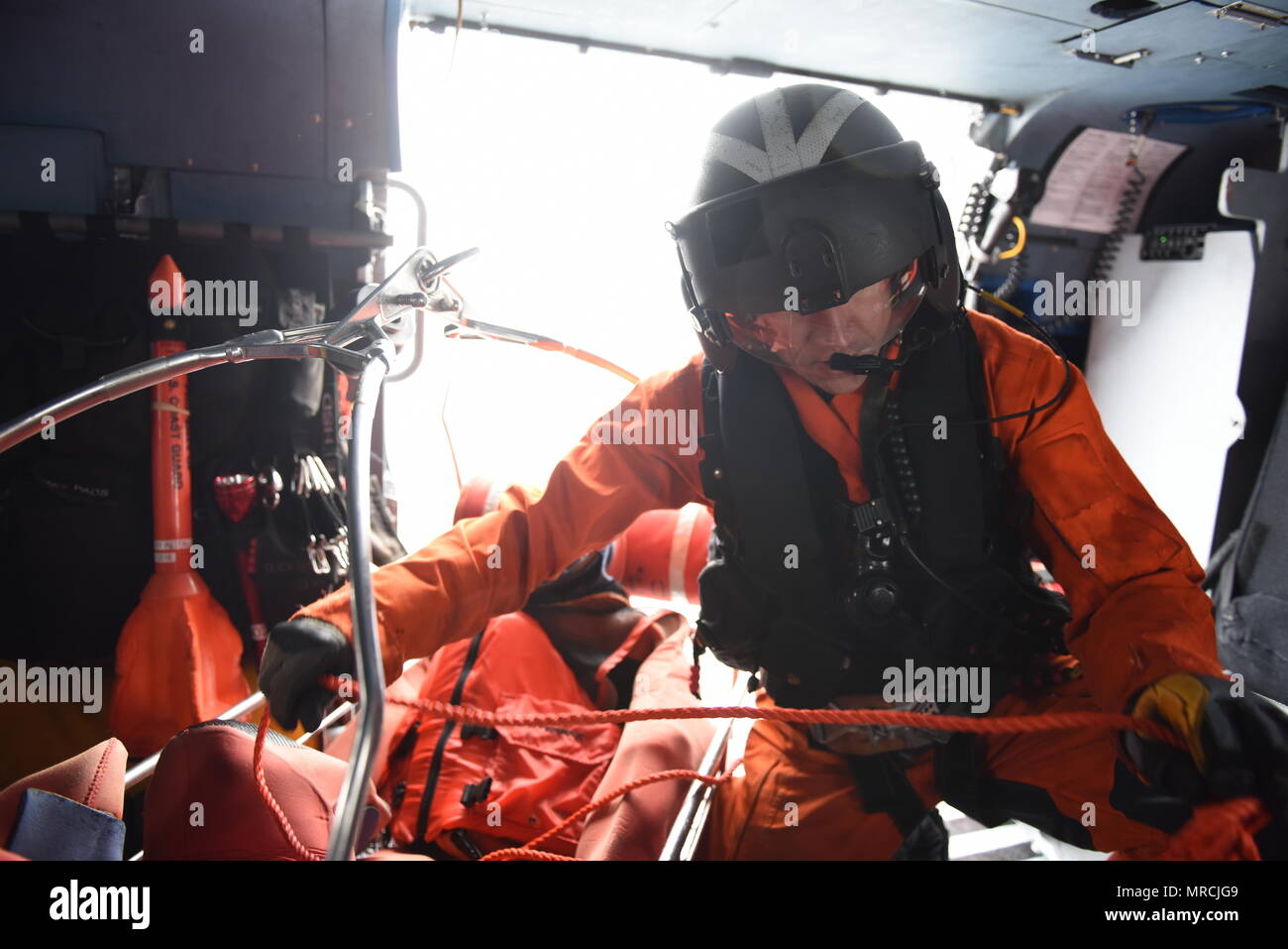 Petty Officer 1st Class Justin Cimbak, an aviation maintenance technician at Coast Guard Sector San Diego, readies the recovery basket for a hoist aboard an MH-60 Jayhawk helicopter during a joint search and rescue exercise with the Mexican navy off the coast of Ensenada, Mexico on June 7, 2017. The exercise simulated a vessel fire that required a coordinated international search and rescue effort. (U.S. Coast Guard photo by Petty Officer 3rd Class Joel Guzman) Stock Photo