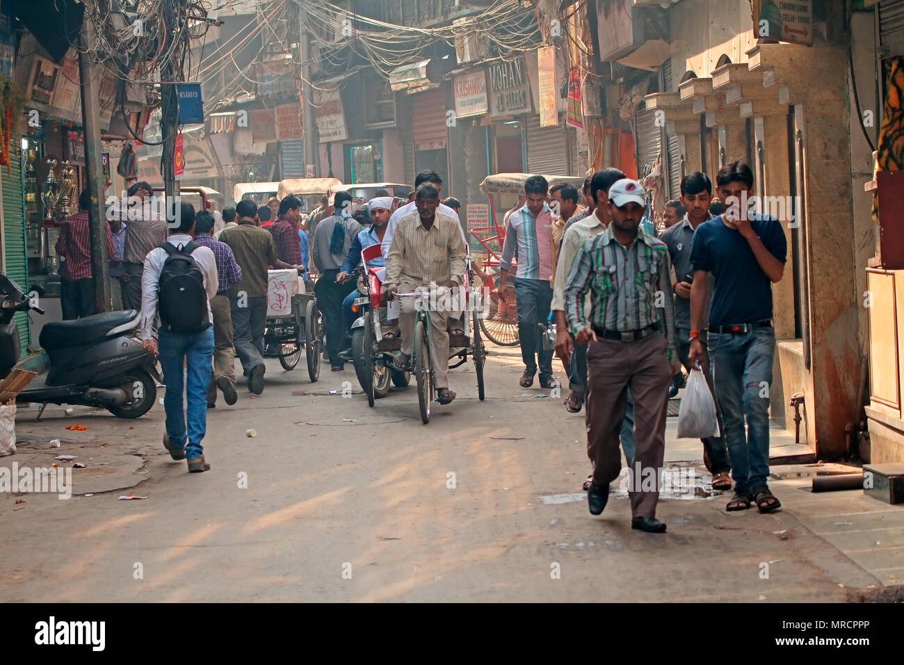 Delhi, India - November 20, 2015: Crowded street with shops in Old Delhi crammed with people busy with their daily activities Stock Photo