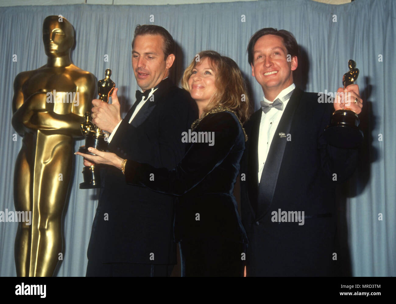 LOS ANGELES, CA - MARCH 25: (L-R) Actor Kevin Costner, singer Barbra Streisand and Jim Wilson attend the 63rd Annual Academy Awards on March 25, 1991 at Shrine Auditorium in Los Angeles, California. Photo by Barry King/Alamy Stock Photo Stock Photo