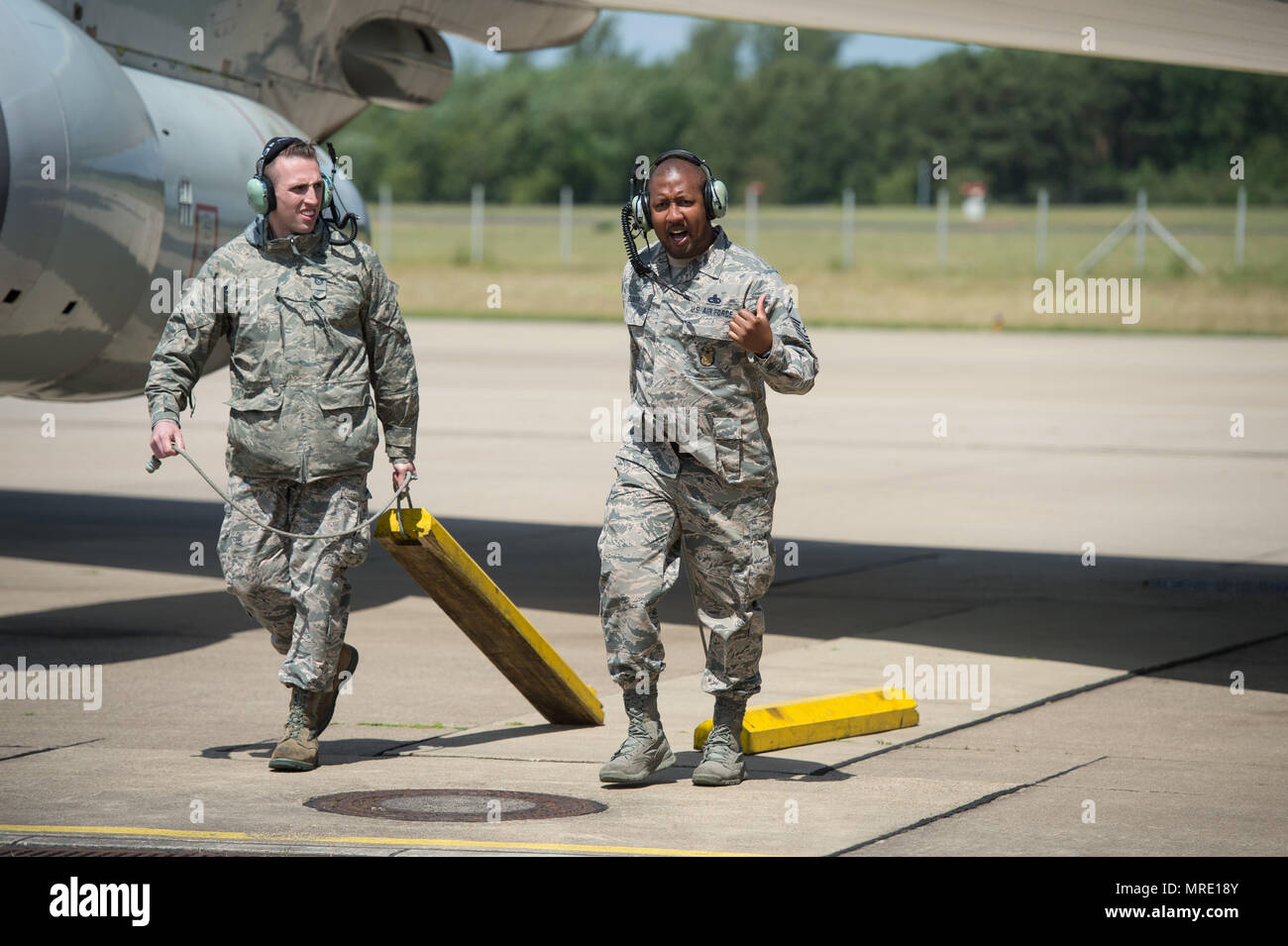 Tech. Sgt. Jordan Wright and Senior Master Sgt. Alphonzo Glover, both maintenance Reservists from the 513th Air Control Group, pull chocks from an E-3 Sentry Airborne Warning and Control System aircraft on June 7, 2017, at NATO Air Base Geilenkirchen, Germany, prior to a mission in support of BALTOPS 2017. Both Airmen are a part of the nearly 100 Reservists supporting the BALTOPS 2017 exercise, which involves 50 ships and submarines and 40 aircraft from 14 member nations. (U.S. Air Force photo/2nd Lt. Caleb Wanzer) Stock Photo