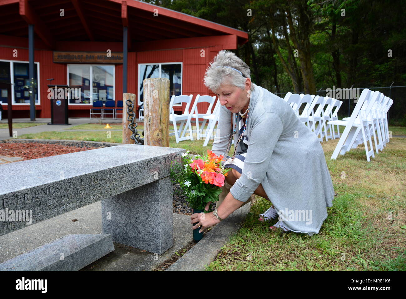 The mother of Lt. j.g. Charles Thigpen IV places flowers at the Humboldt Bay Memorial before a memorial ceremony at Coast Guard Sector Humboldt Bay, June 8, 2017. Thigpen was one of four crewmembers lost in the line of duty 20 years ago when the MH-65 Dolphin helicopter CG-6549 crashed 57 miles west of Cape Mendocino, Calif., during a search-and-rescue mission to save five sailors in a storm. U.S. Coast Guard photo by Petty Officer 3rd Class Sarah Wilson. Stock Photo