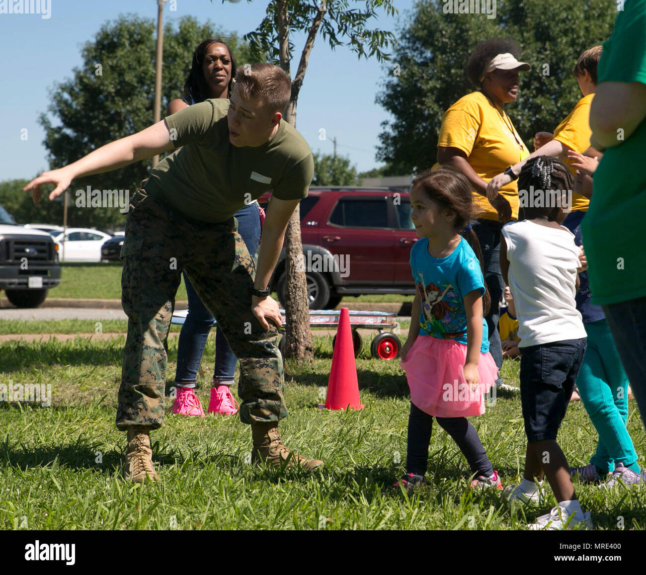 Cpl. Connor Cross, transport noncommissioned officer-in-charge, G-6, U.S. Marine Corps Forces Command, coaches Camp Allen Elementary School students as they race one another in a 50-yard dash during the schools field day event, at Camp Allen Elementary School, Norfolk, Va. Marines assigned to MARFORCOM volunteered to assist the faculty and the students in the events and activities during the school's annual event. (Official U.S. Marine Corps photo by Cpl. Logan Snyder/ Released) Stock Photo