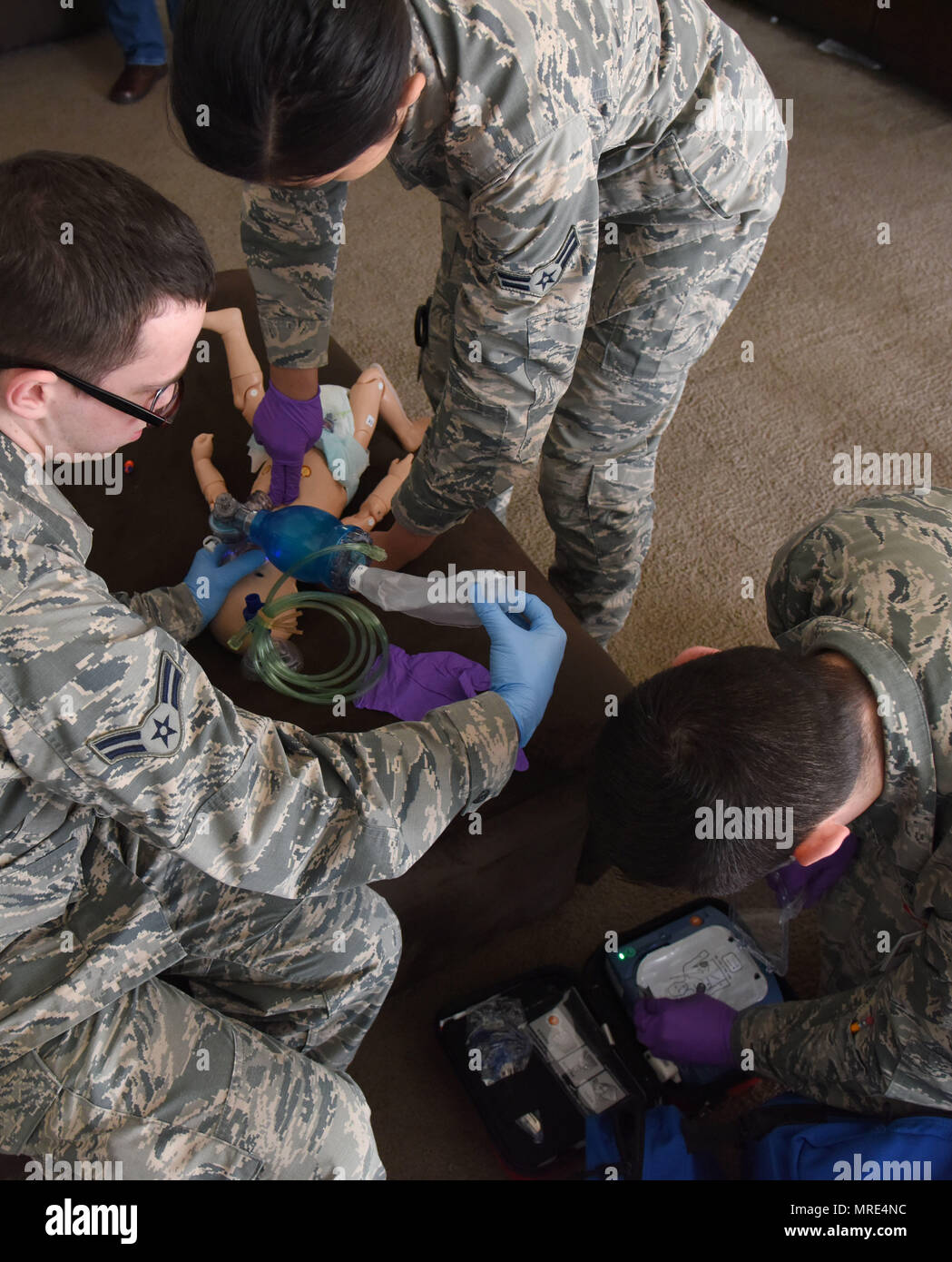 Airmen 1st Class Andrew Frost and Jacqueline Salazar, 81st Medical Operations Squadron medical technicians, and Senior Airman Brock Mauldin, 81st MDOS medical technician, treat an infant “patient” found unresponsive in East Falcon subdivision May 24, 2017, in Biloxi, Miss., as part of a medical emergency scenario. Emergency room staff members coordinated with the simulation lab to use human patient simulators for running various advanced cardiac life support scenarios to improve Keesler’s new medical technicians’ skills and get them familiar with emergency equipment. (U.S. Air Force photo by K Stock Photo