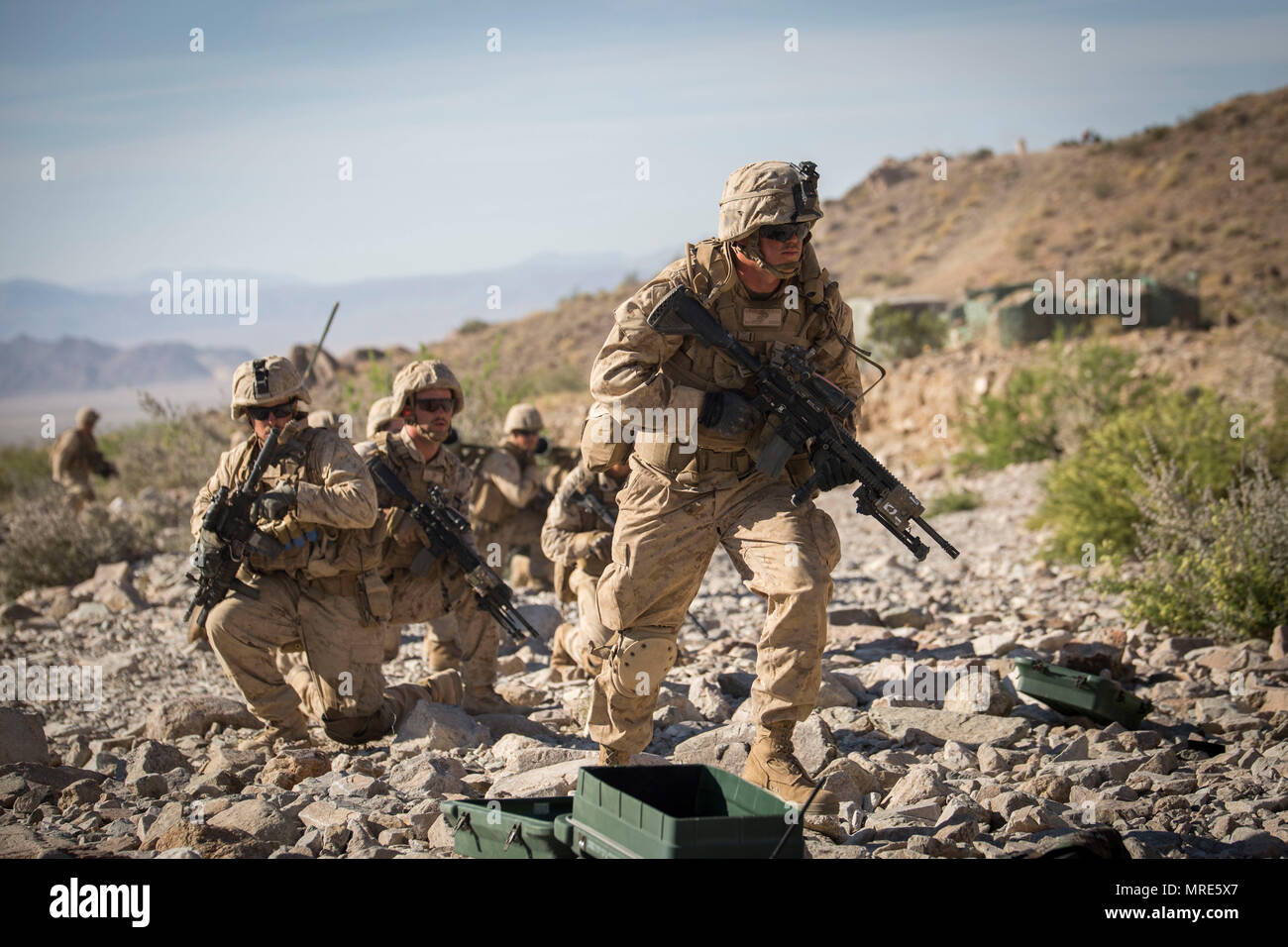MARINE CORPS AIR GROUND COMBAT CENTER TWENTYNINE PALMS, California – Marines with Charlie Company, 1st Battalion, 8th Marine Regiment, prepare to move during a company reinforced assault exercise at Range 400 aboard Marine Corps Air Ground Combat Center, Twentynine Palms, California, May 8, 2017. The Marines conducted a company level assault reinforced by machine guns, vehicles, mortars and snipers as part of Integrated Training Exericse 3-17. ITX is a training evolution conducted five times a year to enhance the lethality and co-operability between the four elements of a Marine Air Ground Tas Stock Photo