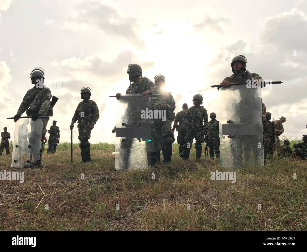 Members of the Antigua, St. Kitts, St. Vincent and Grenada Police Forces  march toward a simulated riot, learning how to handle such an event, during  exercise Tradewinds 2017 at Bushy Park in