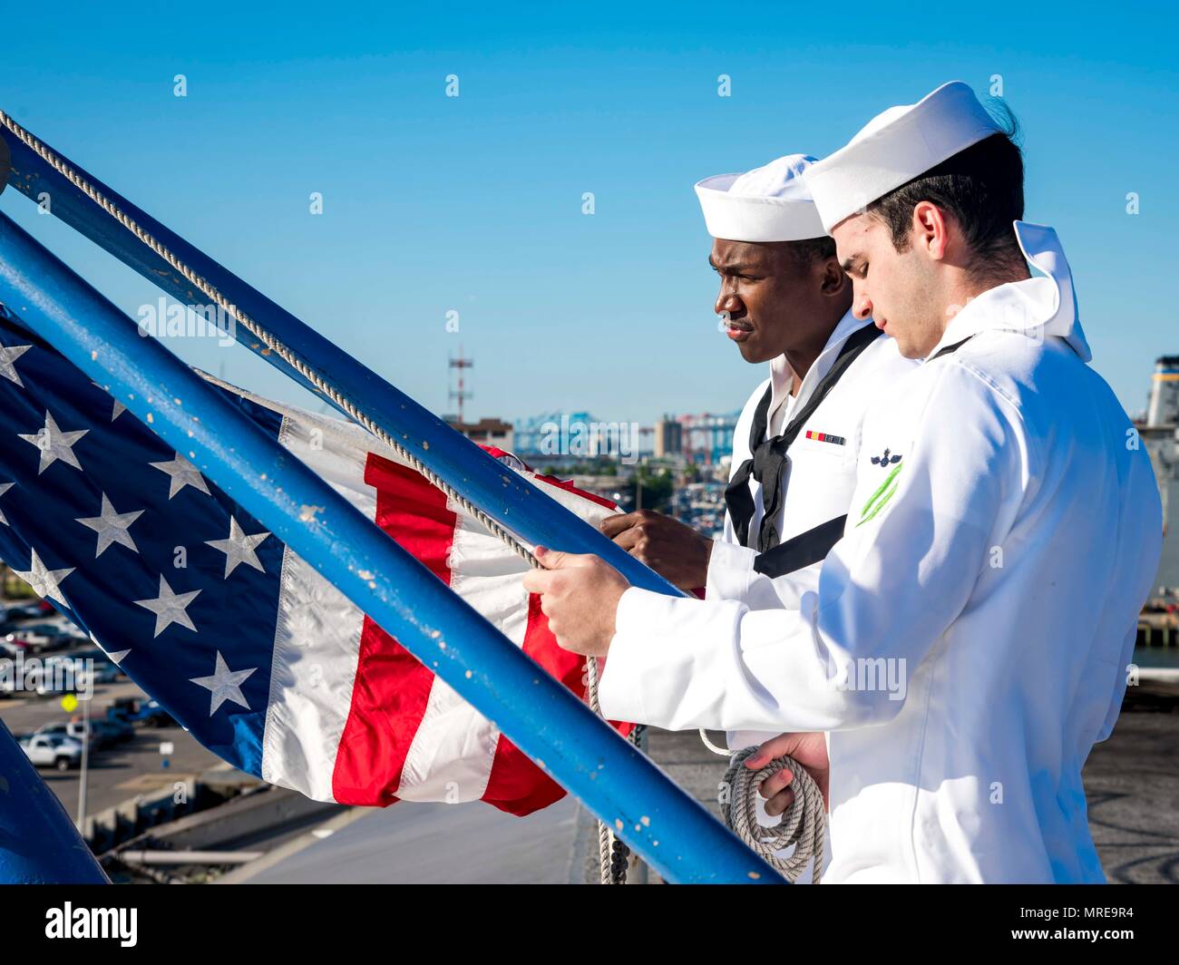 170609-N-FG807-028    NORFOLK, Va. (June 9, 2017)  Aviation Ordnanceman Airman Stephen Jackson, from Auburn, Ala., front, and Aviation Ordnanceman 3rd Class Cyle West, from Great Lakes, prepare to raise the ensign for morning colors aboard the aircraft carrier USS Dwight D. Eisenhower (CVN 69) (Ike). Ike is currently pier side during the sustainment phase of the Optimized Fleet Response Plan (OFRP). (U.S. Navy photo by Mass Communication Specialist Seaman Devin A. Lowe) Stock Photo