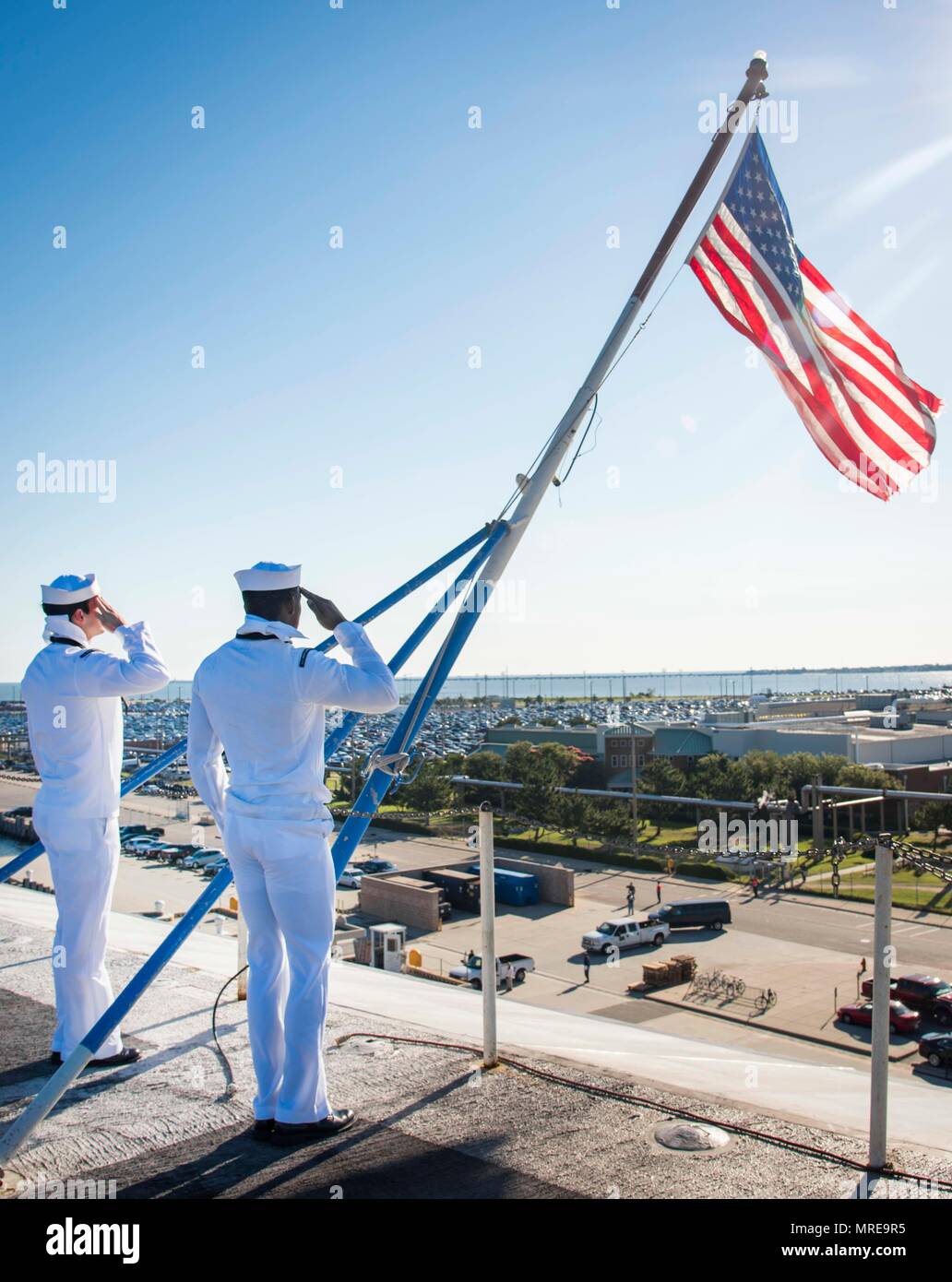 170609-N-FG807-050    NORFOLK, Va. (June 9, 2017)  Aviation Ordnanceman Airman Stephen Jackson, from Auburn, Ala., left, and Aviation Ordnanceman 3rd Class Cyle West, from Great Lakes, salute the ensign during morning colors aboard the aircraft carrier USS Dwight D. Eisenhower (CVN 69) (Ike). Ike is currently pier side during the sustainment phase of the Optimized Fleet Response Plan (OFRP). (U.S. Navy photo by Mass Communication Specialist Seaman Devin A. Lowe) Stock Photo