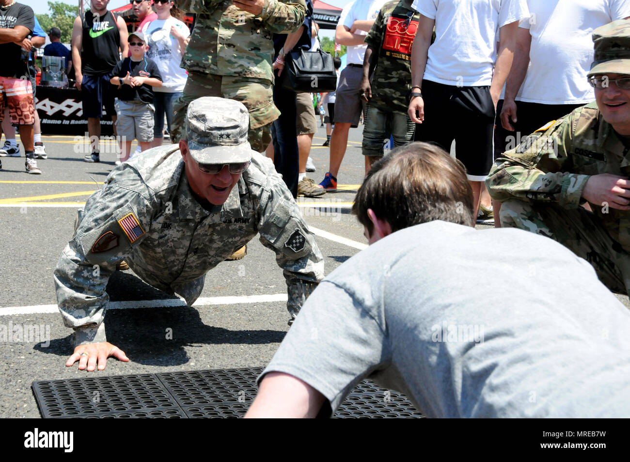 Maj. Gen. Troy D. Kok, commanding general of the U.S. Army Reserve's 99th  Regional Support Command, headquartered at Joint Base  McGuire-Dix-Lakehusrt, New Jersey, completes push-ups with a teenage boy  June 10 at