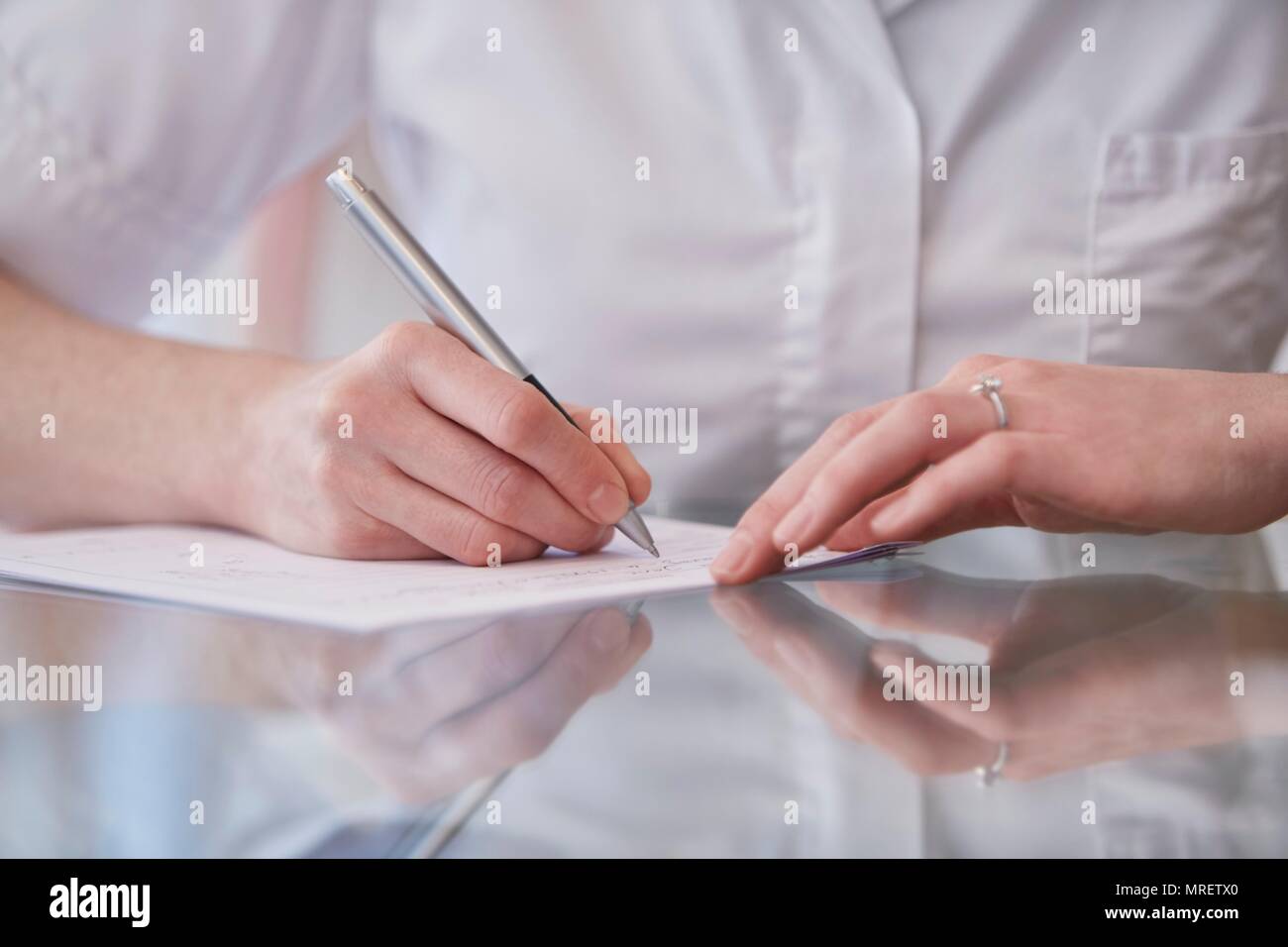 Female osteopath making notes, close up. Stock Photo