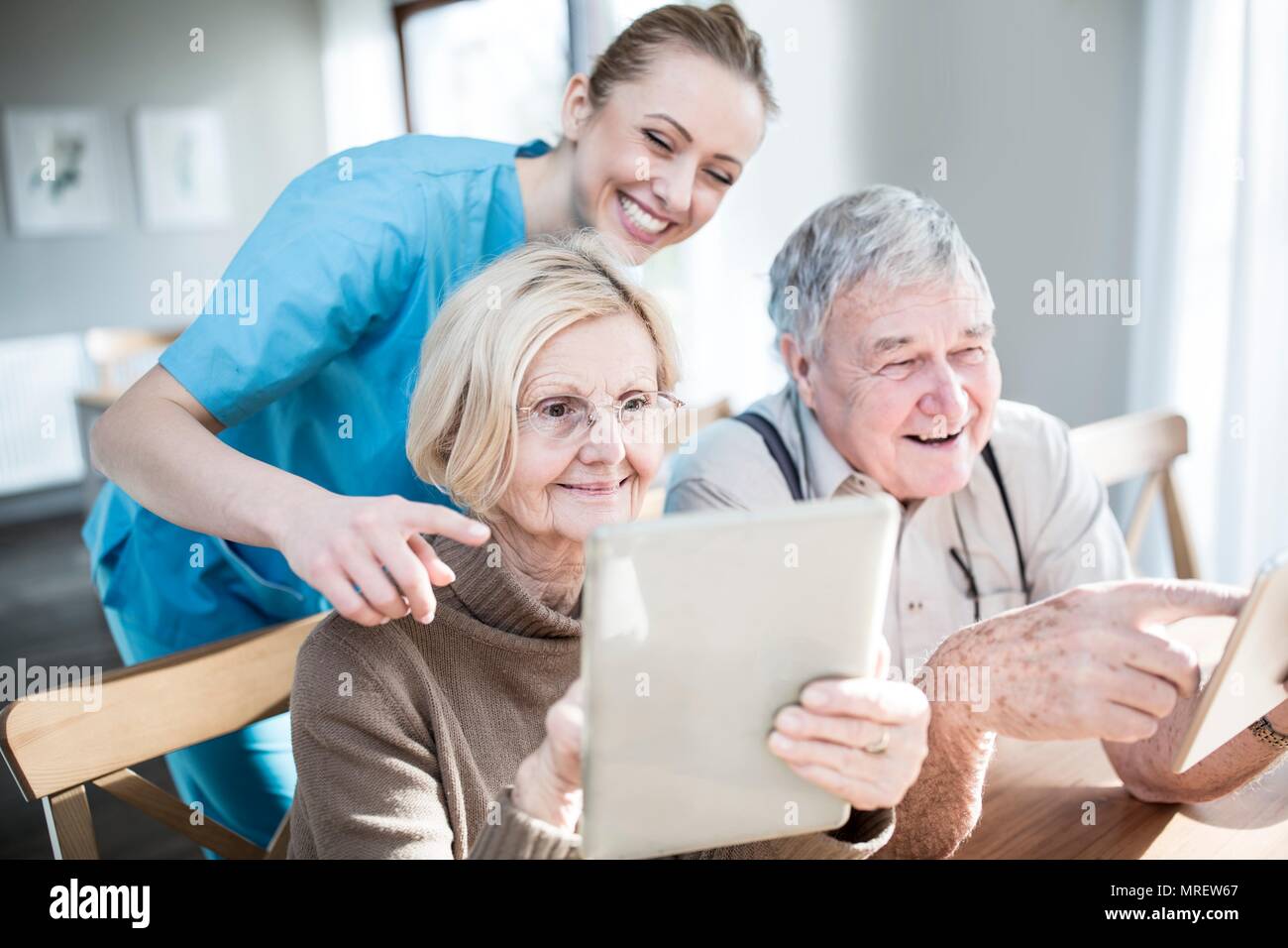 Senior couple using digital tablets in care home. Stock Photo