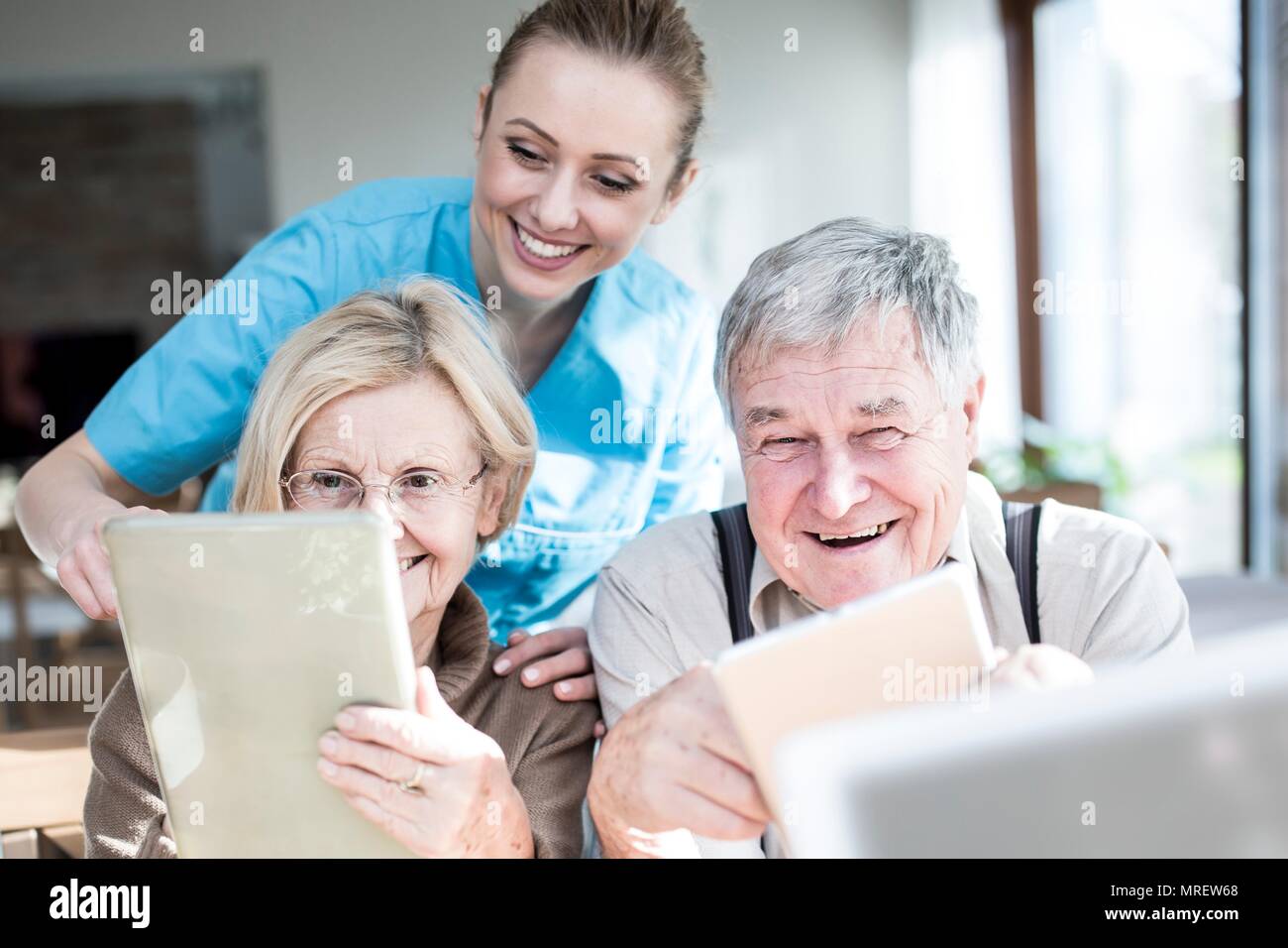 Senior couple using digital tablets in care home. Stock Photo