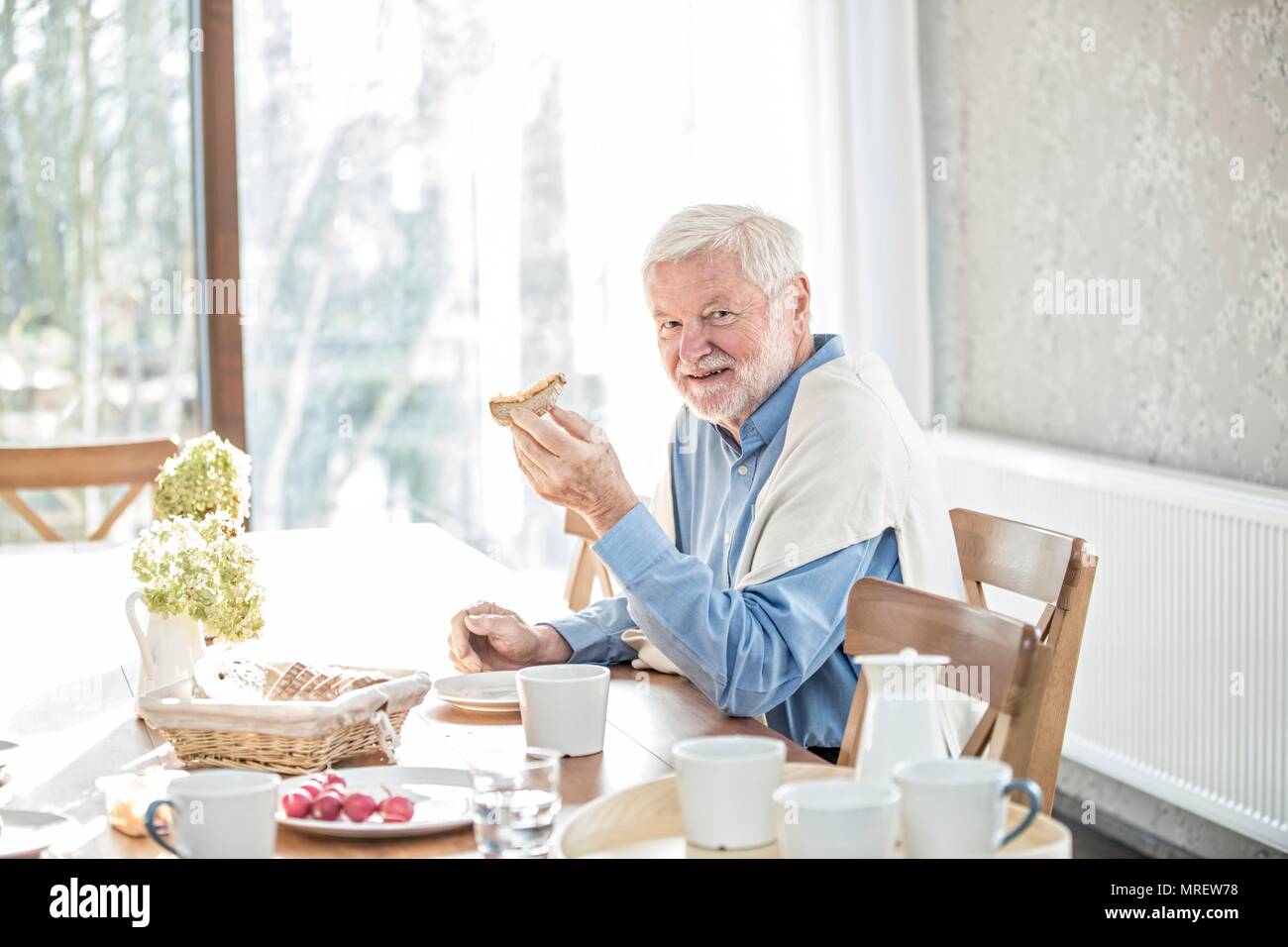 Senior man eating meal in care home. Stock Photo