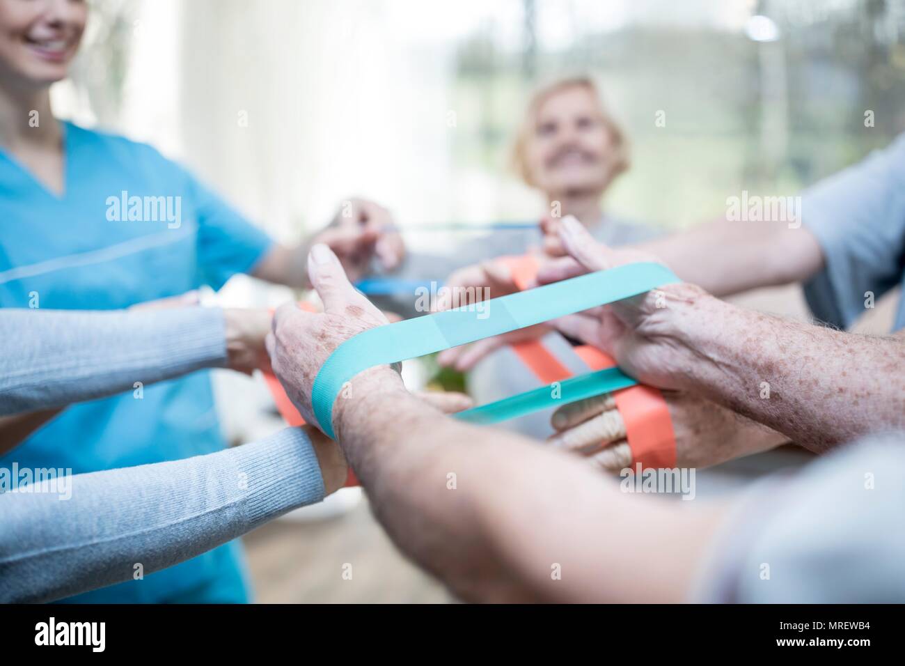 Close up of senior adults using resistance bands in exercise class. Stock Photo