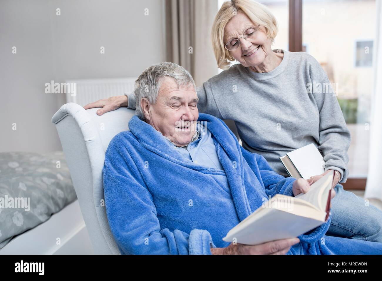 Senior couple reading book in care home. Stock Photo