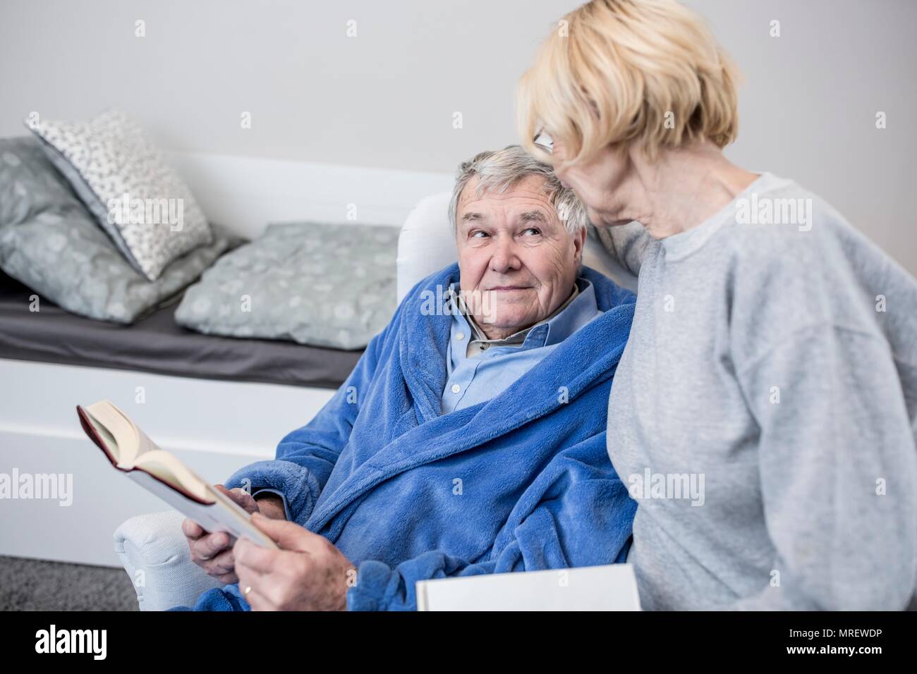 Senior couple reading book in care home. Stock Photo