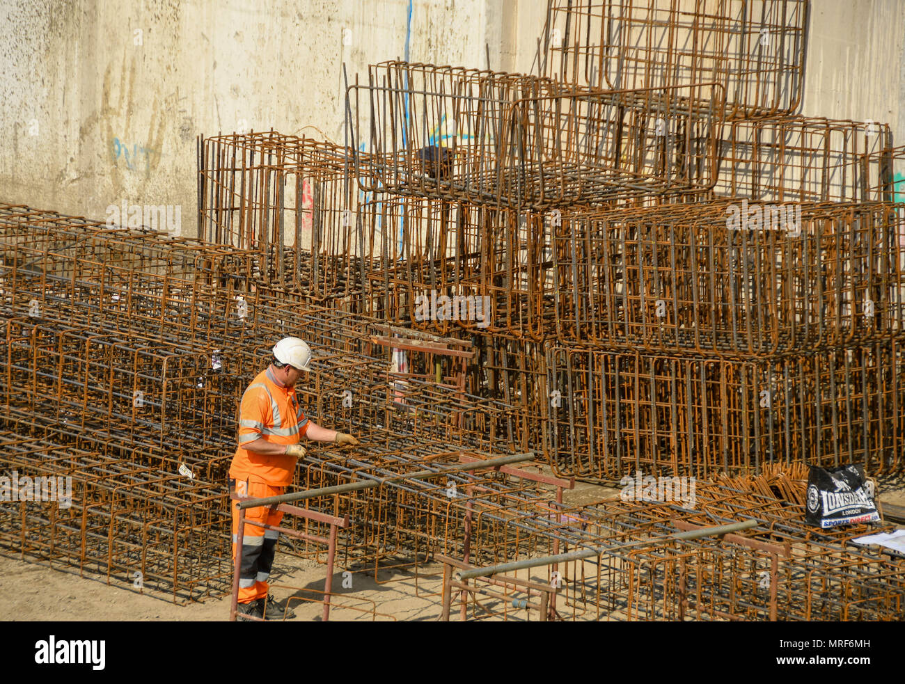 A construction worker assembling steel cages for use in reinforcing concrete for the foundations of a new office development in Pontypridd town centre Stock Photo