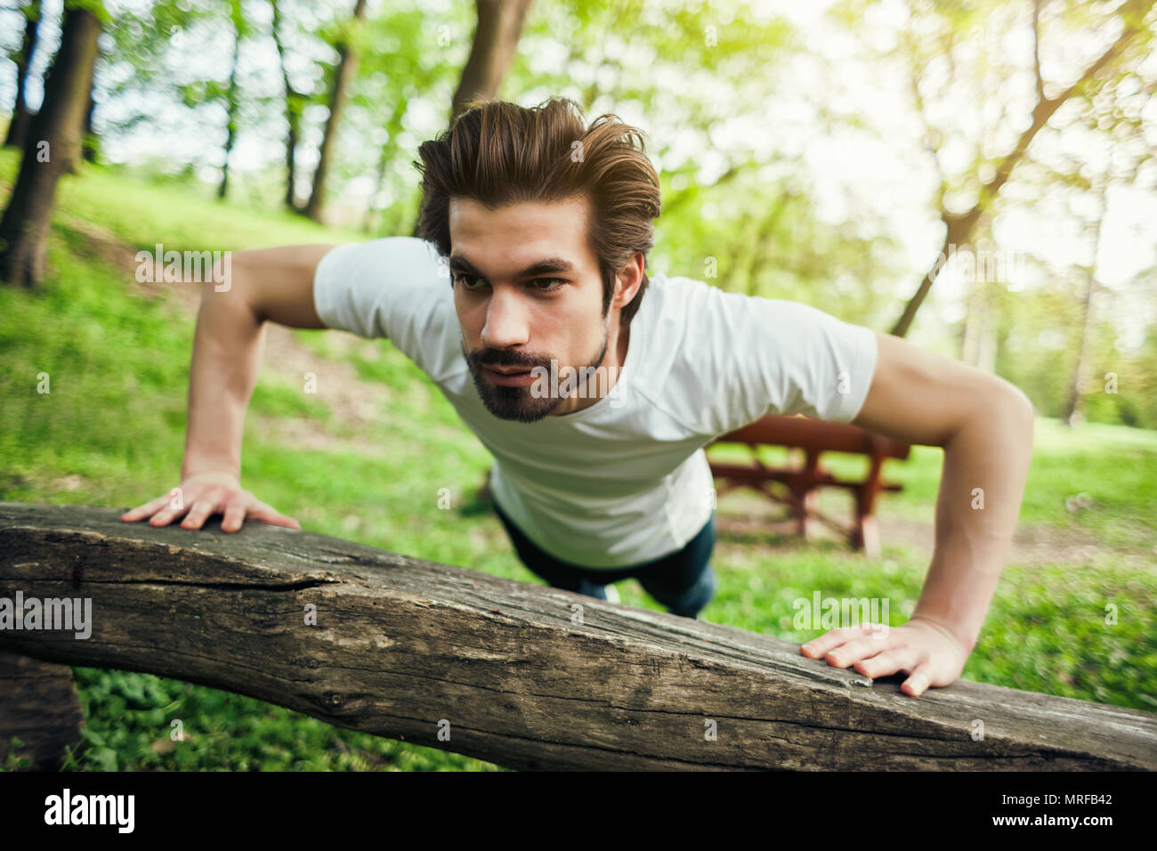 Young man is exercising. He is doing push-ups. Stock Photo
