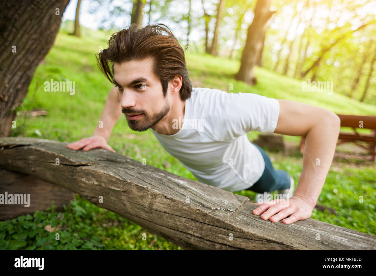 Young man is exercising. He is doing push-ups. Stock Photo