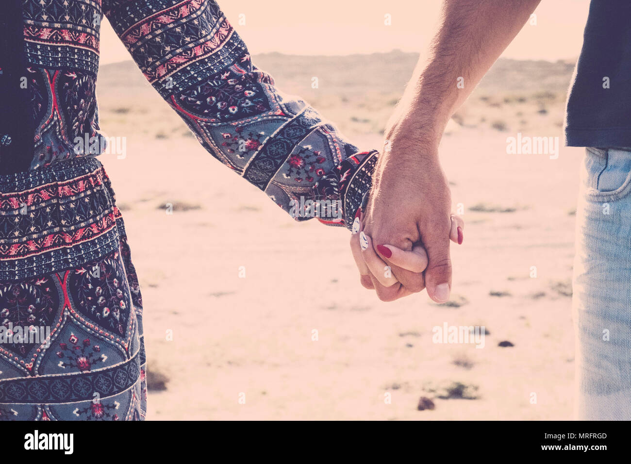 close up of pair of hands together touching holding for real true love between caucasian woman and man. youth traveler in vacation with beach destinat Stock Photo