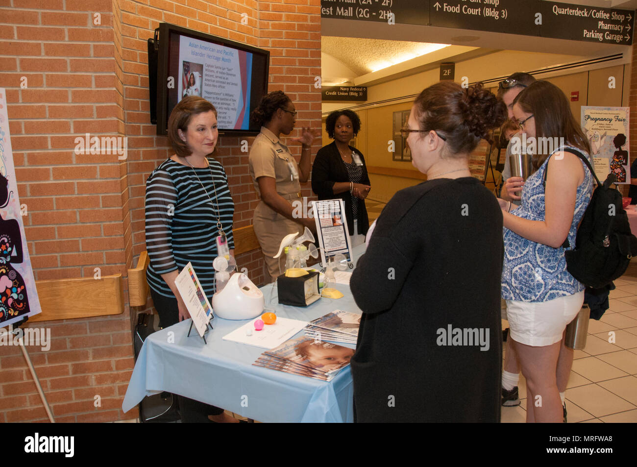 170609-N-GM597-006 Portsmouth, Va. (June 9, 2017) Heather McFarland, left, an outpatient lactation consultant with the Pediatrics Clinic, speaks with a patient about lactation consultant services during the Pregnancy Fair at Naval Medical Center Portsmouth. The Women’s Health Clinic sponsored the fair that offered information on a variety of pregnancy-related topics, including nutrition, exercise, fetal development, birthing positions and lactation. (U.S. Navy photo by Rebecca A. Perron/Released) Stock Photo